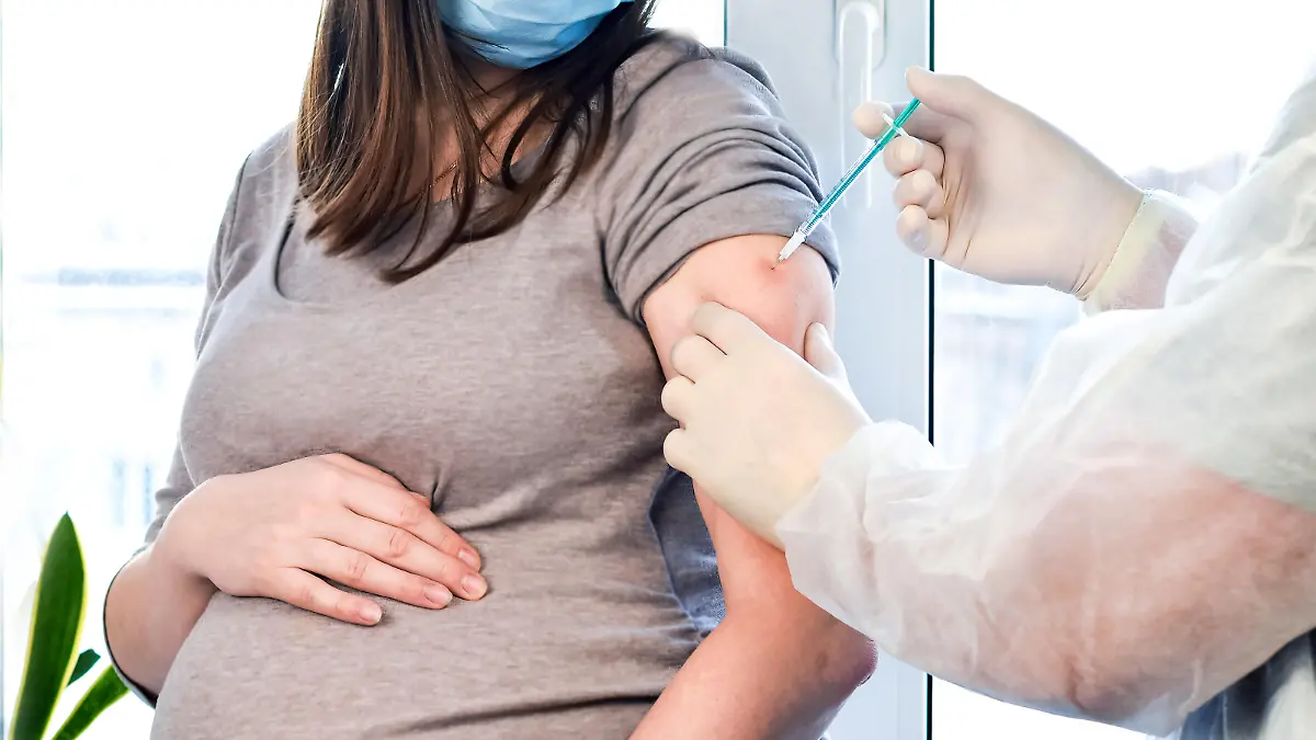 Pregnant Vaccination. Pregnant Woman In Face Mask Getting Vaccinated in Clinic. Doctor Giving Corona Virus Vaccine Injection Patient. Covid-19 Flu Protection.