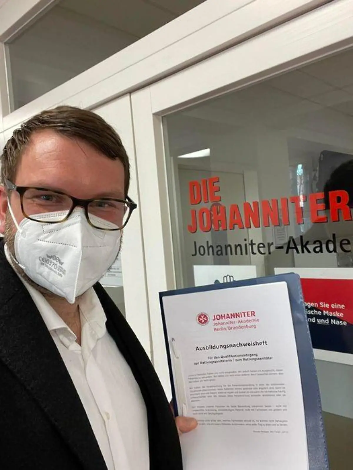 Marian Wendt hält sein Zwischenprüfungszeugnis zur Ausbildung zum Rettungssanitäter.