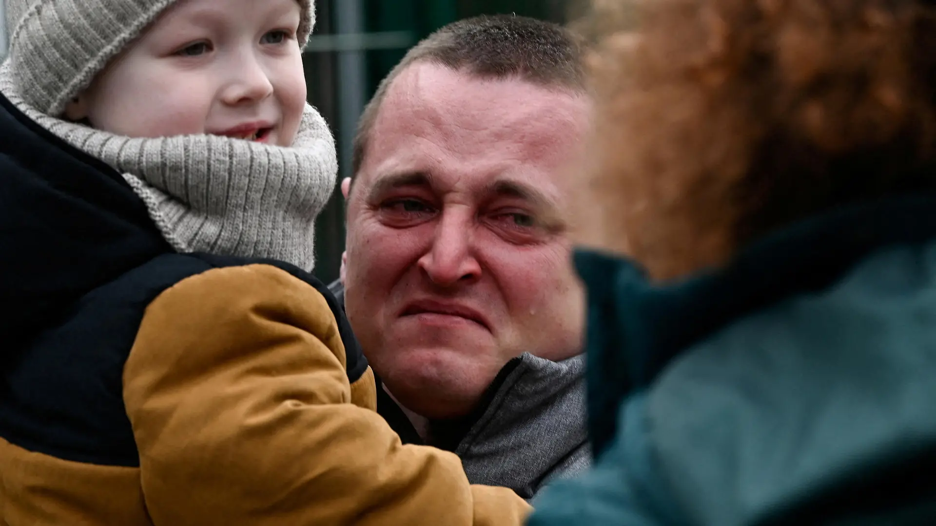 A man holding a child reacts as they arrive from Ukraine to Slovakia, after Russia launched a massive military operation against Ukraine, in Ubla, Slovakia, February 25, 2022. REUTERS/Radovan Stoklasa TPX IMAGES OF THE DAY