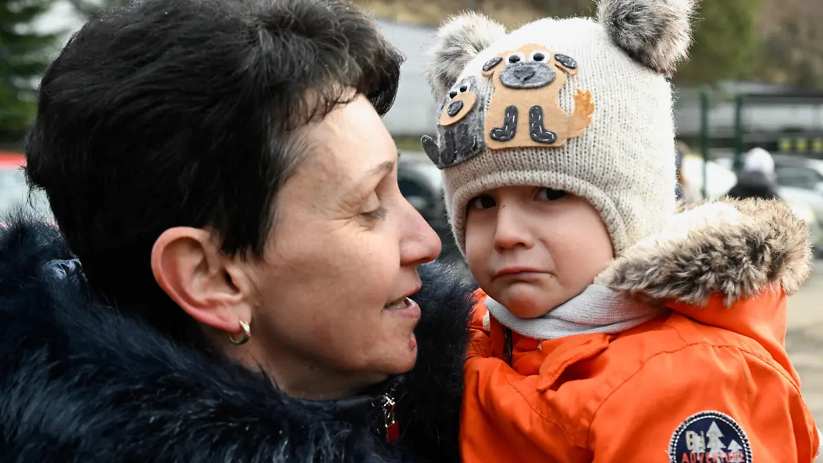 A woman holds a child as they arrive from Ukraine to Slovakia, after Russia launched a massive military operation against Ukraine, in Ubla, Slovakia, February 25, 2022. REUTERS/Radovan Stoklasa