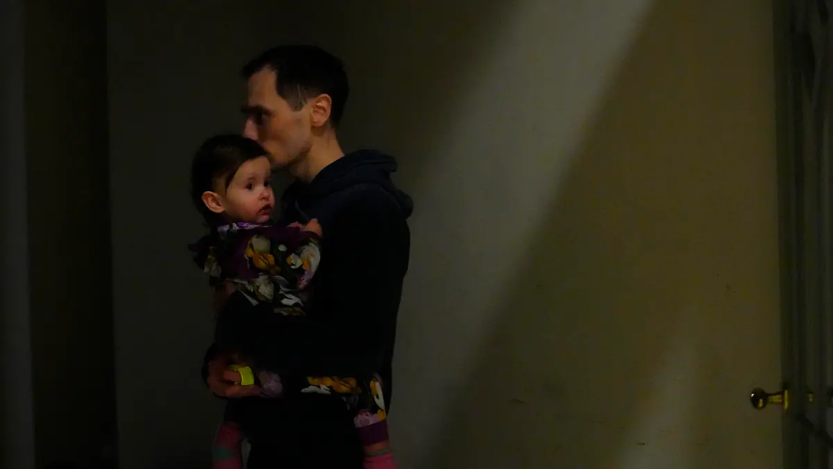 A man from neighboring Ukraine, kisses his daughter at a train station that was turned into an accommodation center in Przemysl, Poland, on Thursday, Feb. 24, 2022. Russia launched a wide-ranging attack on Ukraine on Thursday, hitting cities and bases with airstrikes or shelling, as civilians piled into trains and cars to flee. (AP Photo/Petr David Josek)
