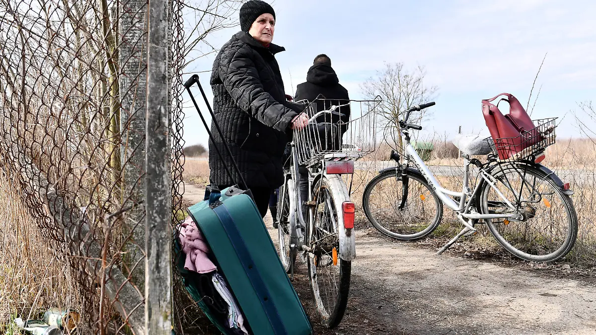 25.02.2022, Ungarn, Barabas: Eine Frau wartet darauf, dass Verwandte sie an der ungarisch-ukrainischen Grenze abholen. Ungarn hat denjenigen, die vor russischen Angriffen fliehen, Schutz gewährt. Foto: Anna Szilagyi/AP/dpa +++ dpa-Bildfunk +++