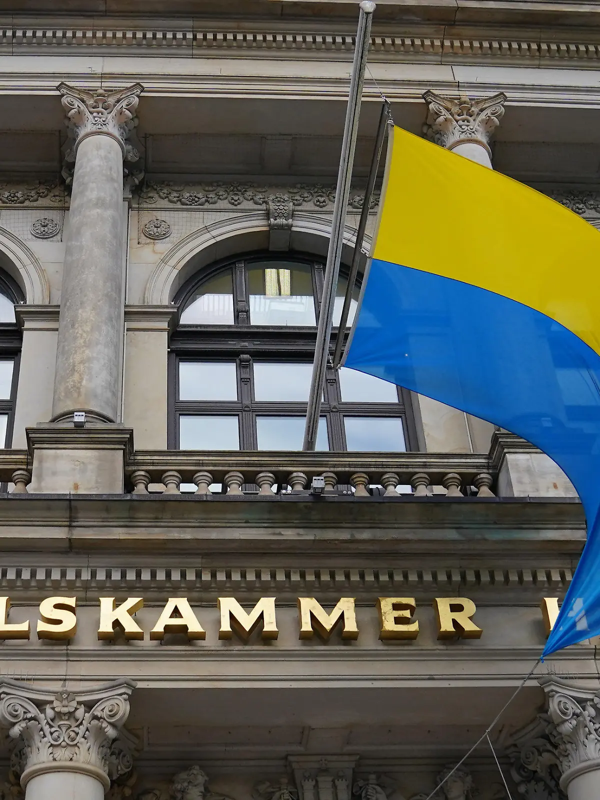 24.02.2022, Hamburg: Die Flagge der Ukraine weht über dem Eingang der Handelskammer Hamburg. Russische Truppen haben ihren erwarteten Angriff auf die Ukraine gestartet. Foto: Marcus Brandt/dpa +++ dpa-Bildfunk +++