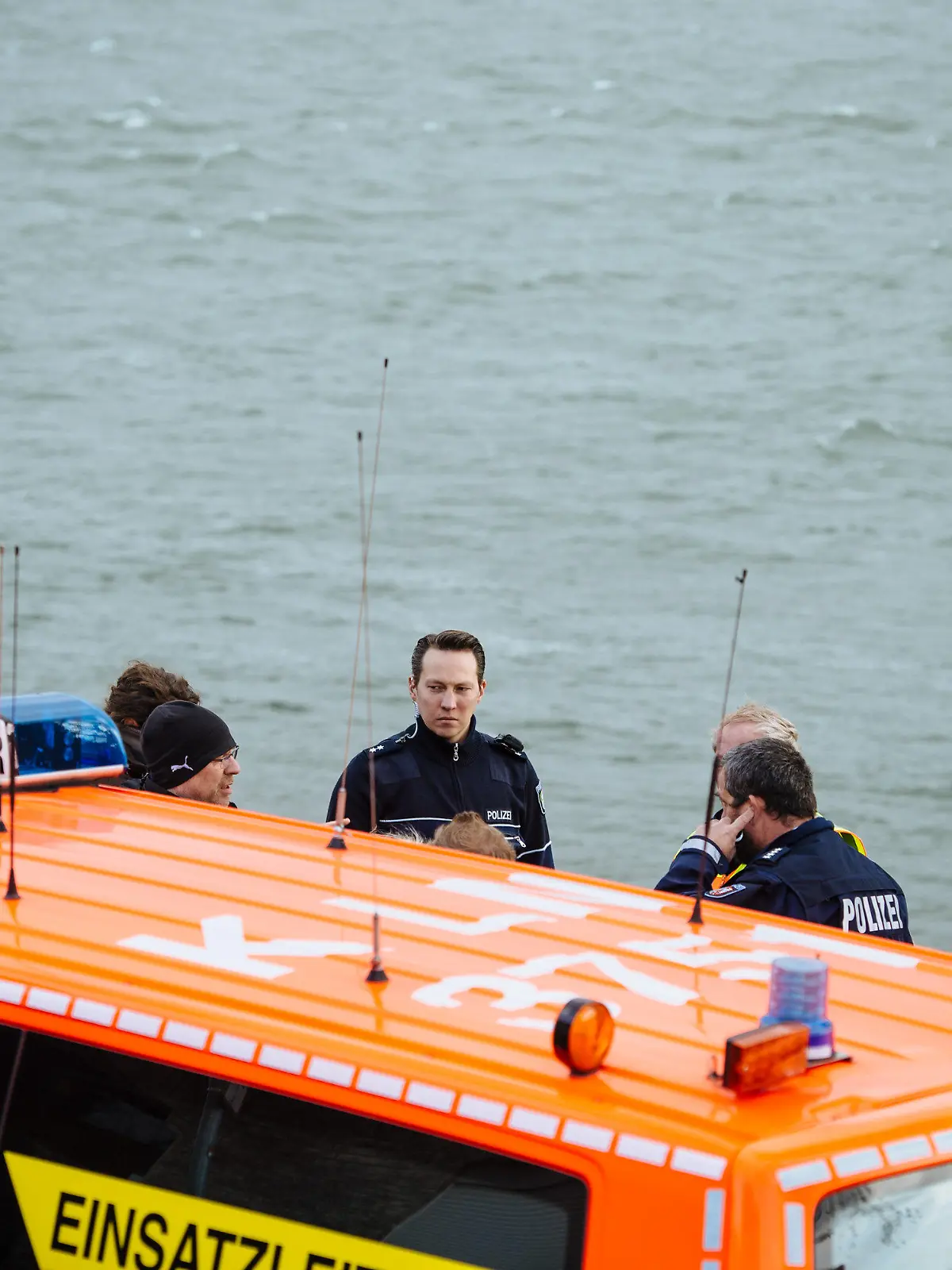 Rettungskräfte von Feuerwehr und Polizei stehen am Rhein in Köln (Nordrhein-Westfalen) am 15.03.2014. Ein sechsjähriges Mädchen ist an dieser Stelle im Fluss ertrunken. Ein Jogger, der hinterher sprang um das Kind zu retten, verschwand in der Strömung und blieb trotz zweistündiger Suche mit Rettungsbooten und Hubschraubern im Rhein verschwunden. Foto: Costa Belibasakis/dpa +++(c) dpa - Bildfunk+++