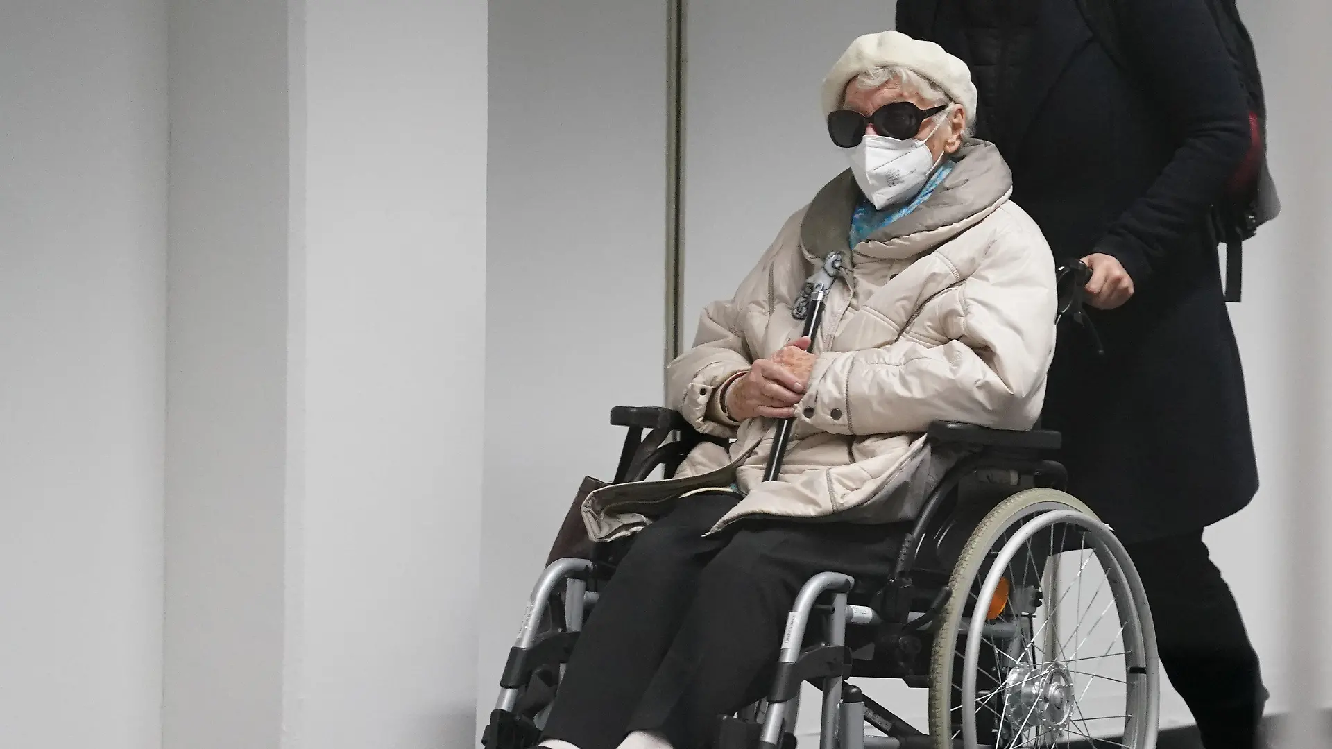 15.02.2022, Schleswig-Holstein, Itzehoe: Die 96-jährige Angeklagte Irmgard F. wird in einem Rollstuhl in den Gerichtssaal geschoben. Der Prozess gegen die ehemalige KZ-Sekretärin vor dem Landgericht Itzehoe wird fortgesetzt. Der 96-Jährigen wird Beihilfe zum Mord in über 11.000 Fällen im Konzentrationslager Stutthof zur Last gelegt. Foto: Marcus Brandt/dpa Pool/dpa +++ dpa-Bildfunk +++