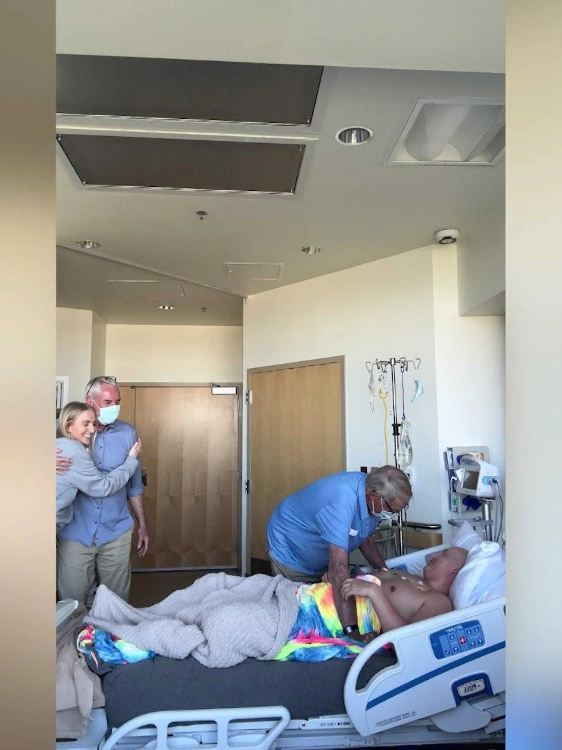Ein Großvater besucht seinen krebskranken Enkel am Krankenbett.