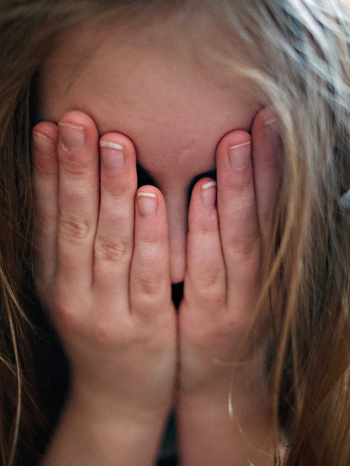 ARCHIV - 24.01.2014, Berlin: ILLUSTRATION - Ein junges Mädchen hält sich die Hände vor sein Gesicht. Im ersten Lockdown im Frühjahr sind deutlich weniger Kinder und Jugendliche in Bayern in einem Krankenhaus behandelt worden als üblich - stationäre Einweisungen wegen Depressionen und Angststörungen hingegen nahmen zu. (zu dpa: Zufa "Kinder und Jugendliche in der Corona-Falle: Experten fordern rasche Hilfe") Foto: Nicolas Armer/dpa +++ dpa-Bildfunk +++