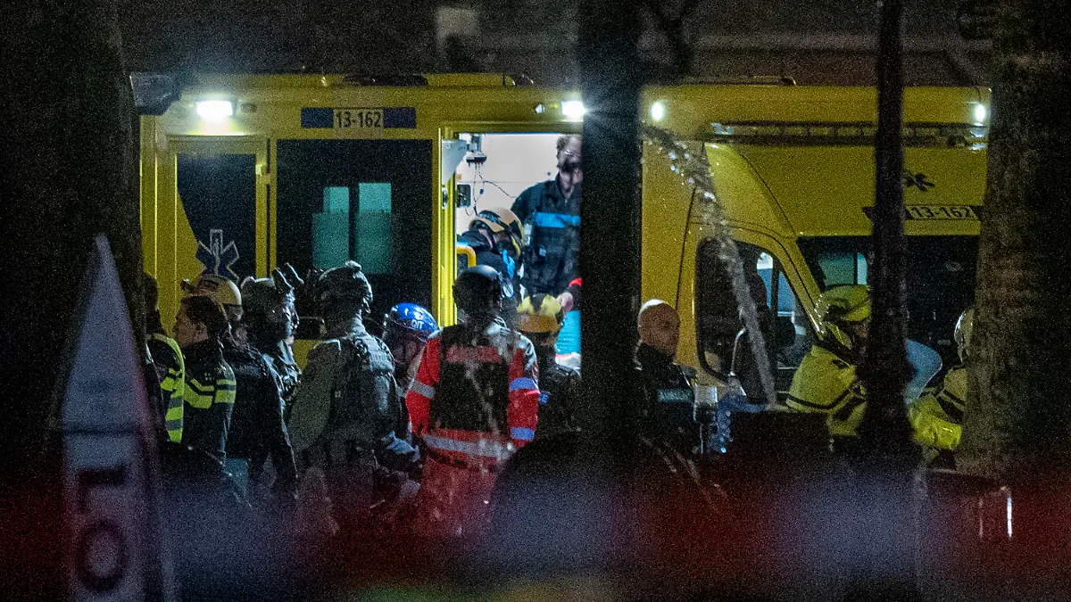 Police special intervention units and rescue workers are seen as the injured hostage taker is carried into an ambulance in Amsterdam, Netherlands, Tuesday, Feb. 22, 2022, where the armed person was holed up in the Apple Store with at least one hostage in an hours-long standoff with scores of police massed outside. (AP Photo/Peter Dejong)