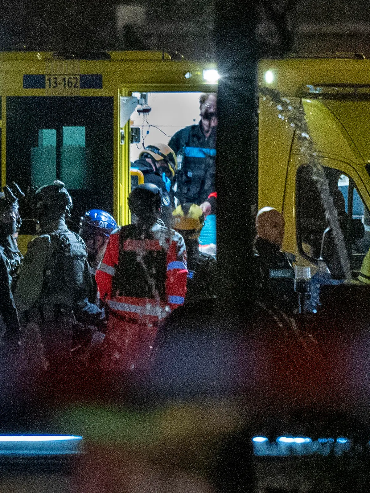 Police special intervention units and rescue workers are seen as the injured hostage taker is carried into an ambulance in Amsterdam, Netherlands, Tuesday, Feb. 22, 2022, where the armed person was holed up in the Apple Store with at least one hostage in an hours-long standoff with scores of police massed outside. (AP Photo/Peter Dejong)
