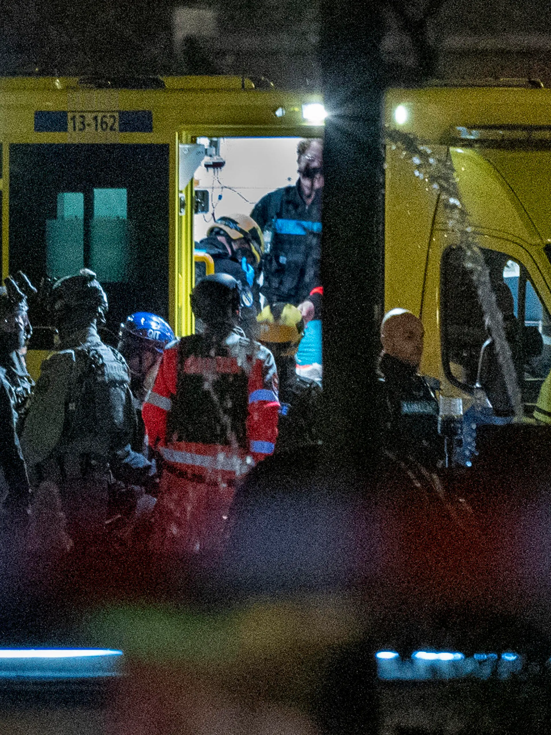 Police special intervention units and rescue workers are seen as the injured hostage taker is carried into an ambulance in Amsterdam, Netherlands, Tuesday, Feb. 22, 2022, where the armed person was holed up in the Apple Store with at least one hostage in an hours-long standoff with scores of police massed outside. (AP Photo/Peter Dejong)