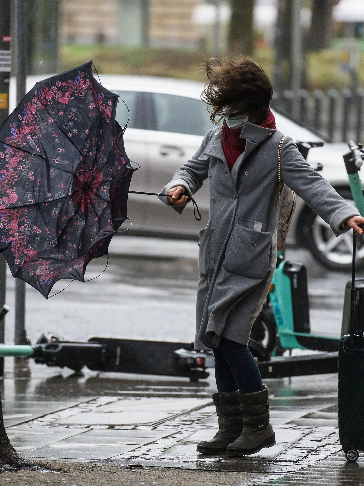 06.02.2022, Hessen, Frankfurt/Main: Eine Frau kämpft mit dem stürmischen Wind, während sie versucht, in der Frankfurter Innenstadt eine Straße zu überqueren. Foto: Frank Rumpenhorst/dpa +++ dpa-Bildfunk +++