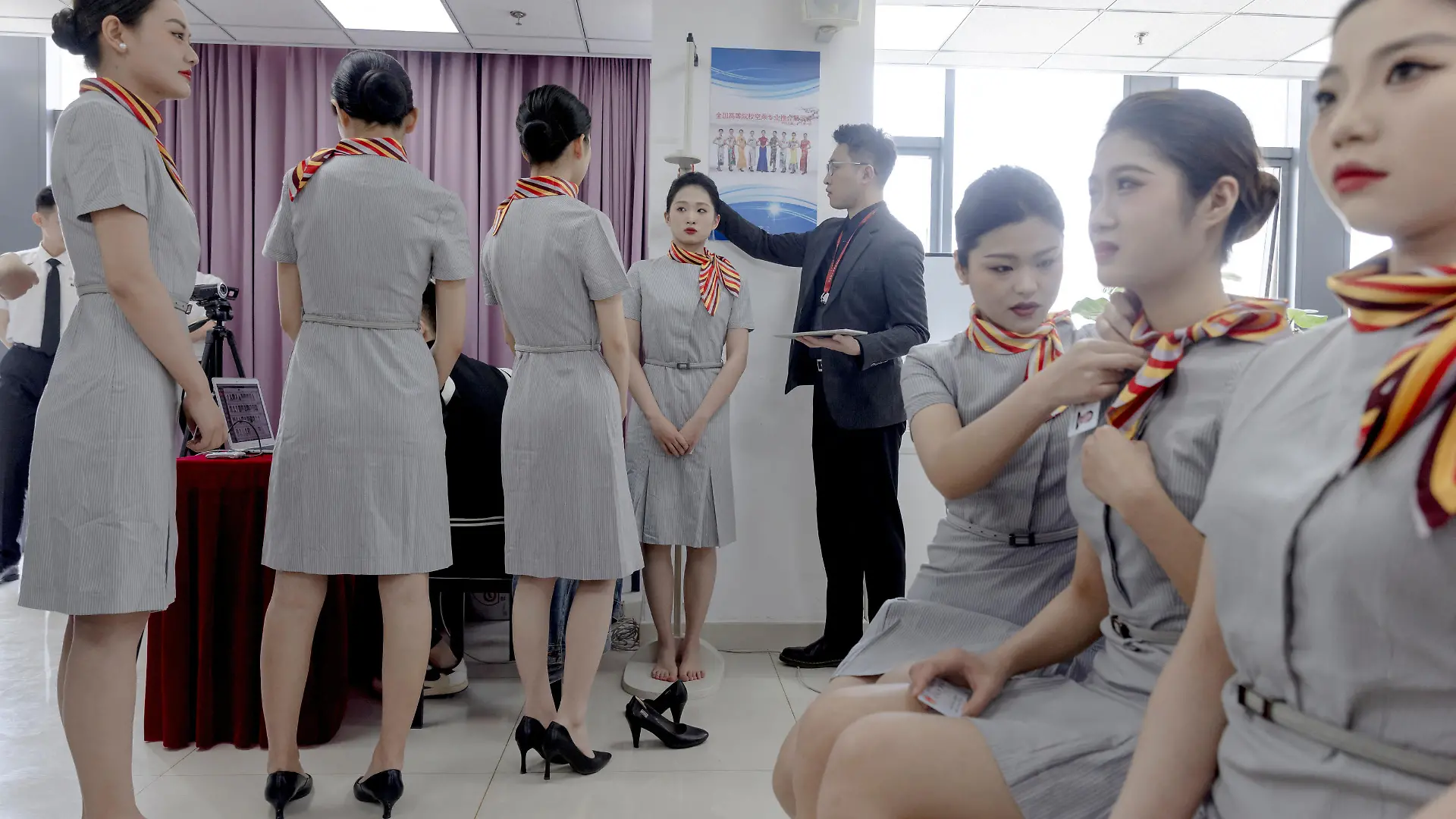 An applicant is measured for height during a recruiting session for cabin crew jobs at Hainan Airlines in Beijing, China, March 30, 2023. REUTERS/Thomas Peter
