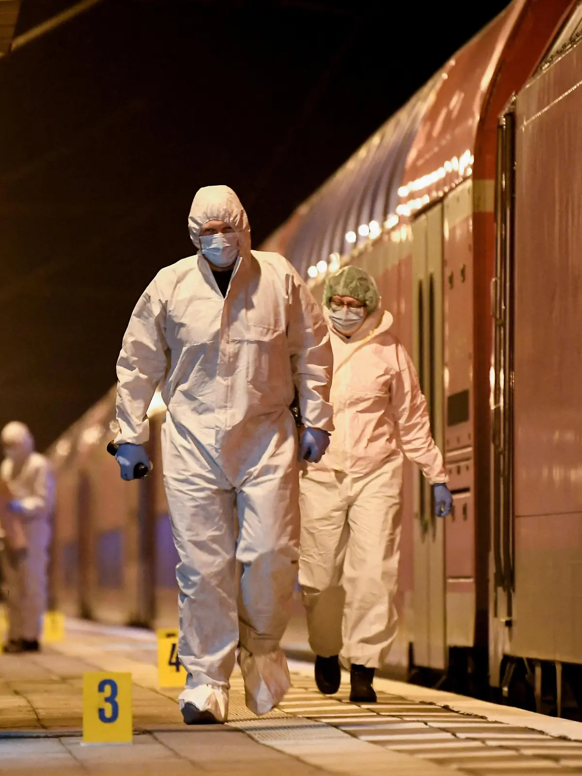 Forensic experts walk next to a train on which an incident involving a knife attack took place, at a railway station in Brokstedt, Germany, January 25, 2023.   REUTERS/Fabian Bimmer     TPX IMAGES OF THE DAY