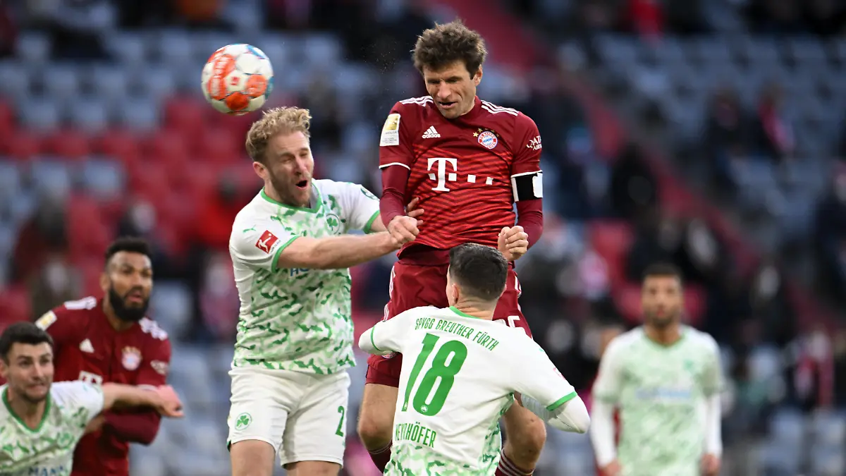 20.02.2022, Bayern, München: Fußball: Bundesliga, Bayern München - SpVgg Greuther Fürth, 23. Spieltag, Allianz Arena. Bayerns Thomas Müller (M) in Aktion gegen Fürths Simon Asta (l). WICHTIGER HINWEIS: Gemäß den Vorgaben der DFL Deutsche Fußball Liga bzw. des DFB Deutscher Fußball-Bund ist es untersagt, in dem Stadion und/oder vom Spiel angefertigte Fotoaufnahmen in Form von Sequenzbildern und/oder videoähnlichen Fotostrecken zu verwerten bzw. verwerten zu lassen. Foto: Tobias Hase/dpa +++ dpa-Bildfunk +++