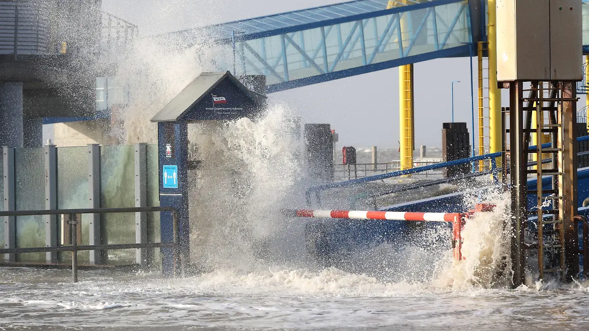 30.01.2022, Schleswig-Holstein, Dagebüll: Die Gischt der aufgepeitschten Nordsee überflutet bei Sturm den Fähranleger Dagebüll. Foto: Bodo Marks//dpa +++ dpa-Bildfunk +++