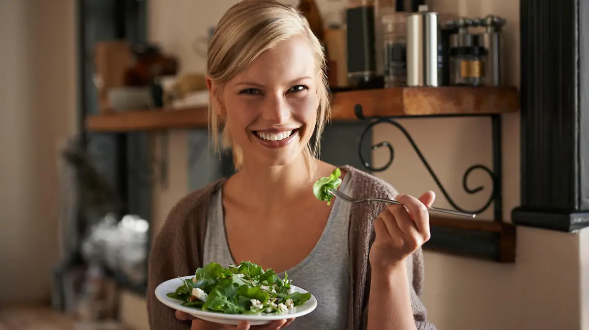 Portrait of an attractive young woman eating a salad in her kitchen