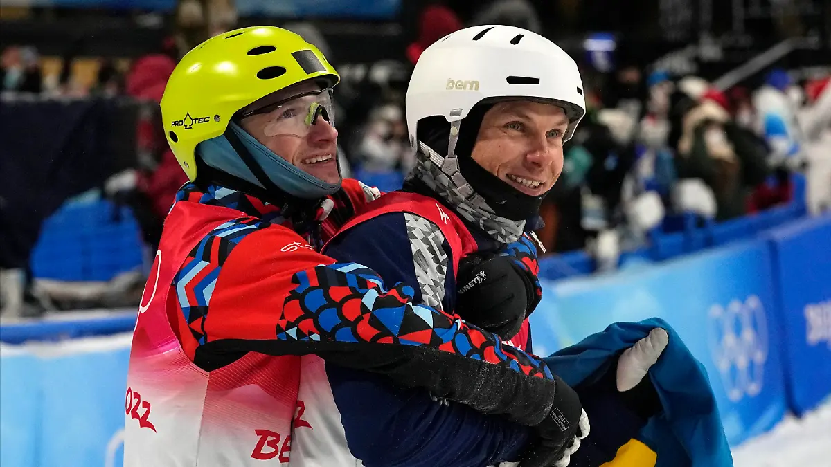 Bronze medal winner Ilia Burov, of the Russian Olympic Committee, left, hugs silver medal winner Ukraine's Oleksandr Abramenko as they celebrate after the men's aerials finals at the 2022 Winter Olympics, Wednesday, Feb. 16, 2022, in Zhangjiakou, China. (AP Photo/Gregory Bull)