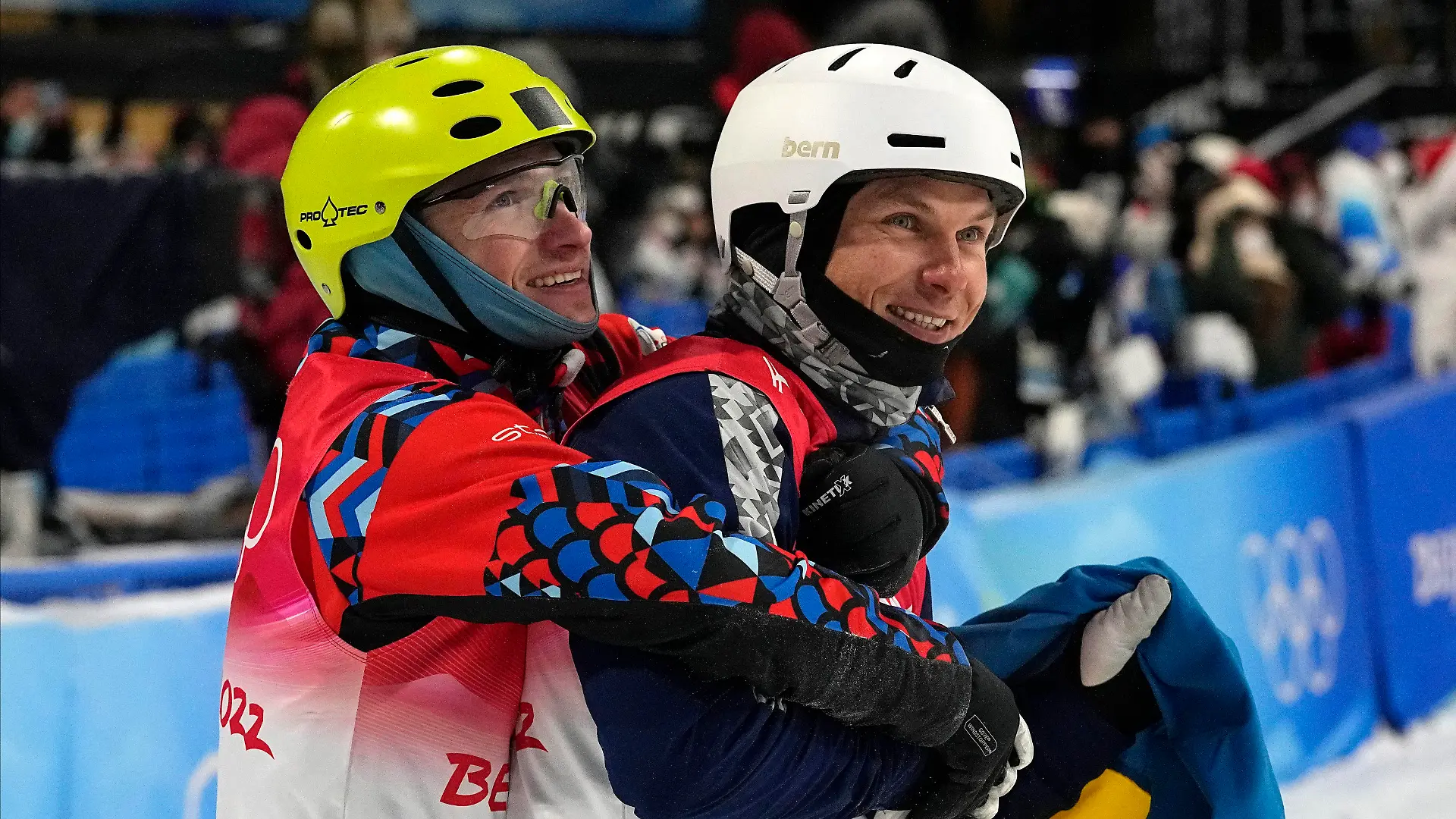 Bronze medal winner Ilia Burov, of the Russian Olympic Committee, left, hugs silver medal winner Ukraine's Oleksandr Abramenko as they celebrate after the men's aerials finals at the 2022 Winter Olympics, Wednesday, Feb. 16, 2022, in Zhangjiakou, China. (AP Photo/Gregory Bull)