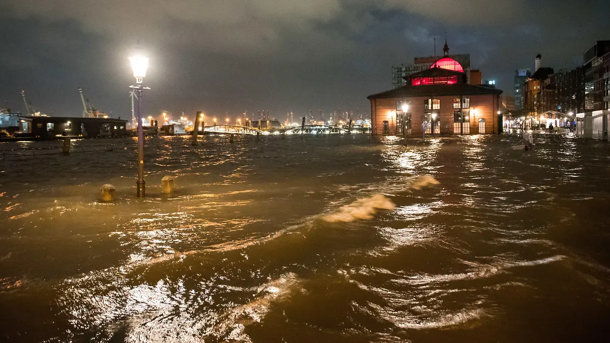 17.02.2022, Hamburg: Der Fischmarkt mit der Fischauktionshalle ist am Morgen während einer Sturmflut beim Hochwasser der Elbe überschwemmt. Der Hamburger Fischmarkt ist am frühen Donnerstagmorgen erneut überflutet worden. «Am Pegel St. Pauli wurde gegen 5.00 Uhr ein Wert von 1,98 Meter über dem mittleren Hochwasser (MHW) gemessen», sagte ein Sprecher des Sturmflutwarndienstes des Bundesamts für Seeschifffahrt und Hydrographie (BSH) in Hamburg. Foto: Daniel Bockwoldt/dpa +++ dpa-Bildfunk +++