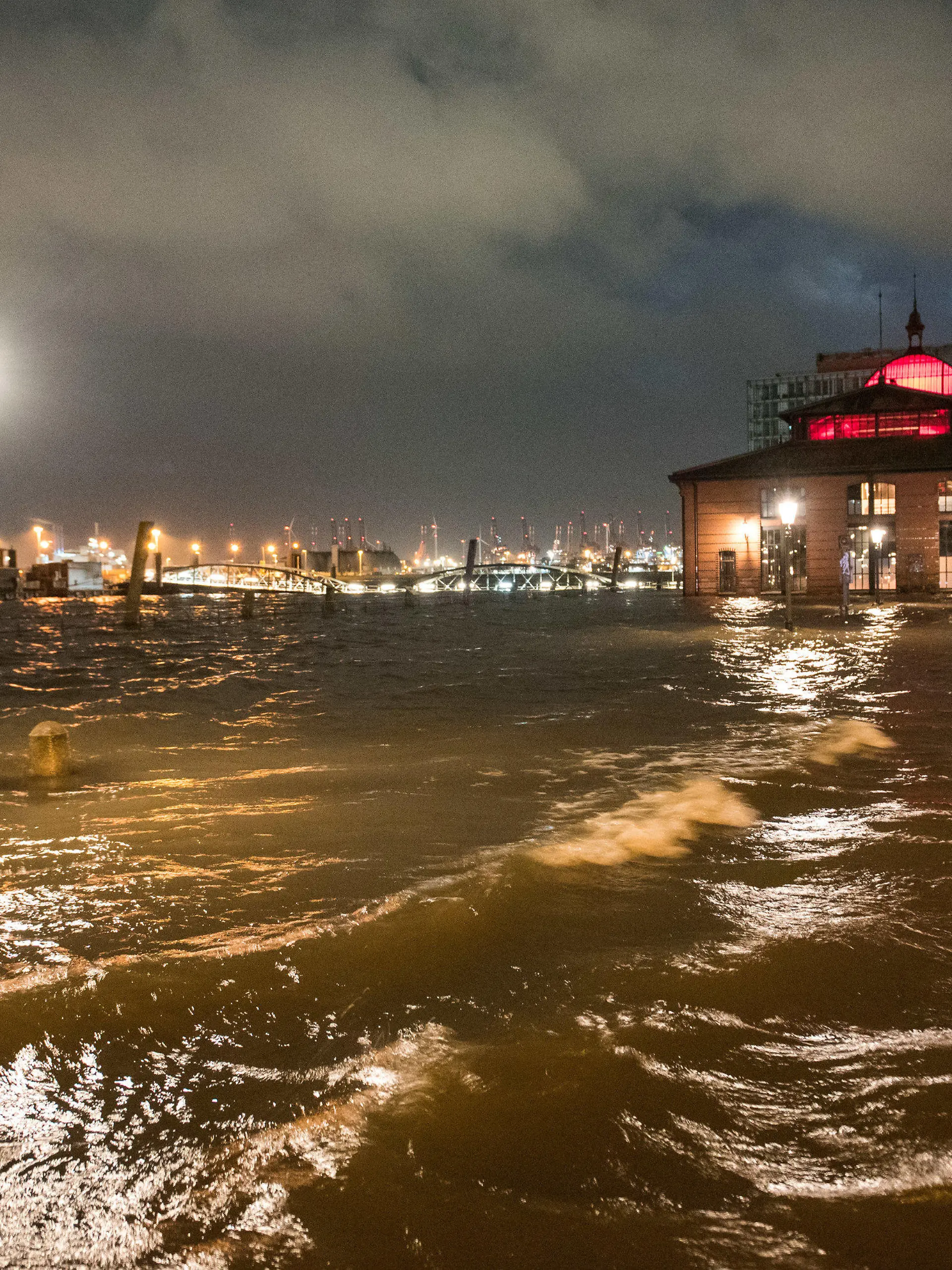 17.02.2022, Hamburg: Der Fischmarkt mit der Fischauktionshalle ist am Morgen während einer Sturmflut beim Hochwasser der Elbe überschwemmt. Der Hamburger Fischmarkt ist am frühen Donnerstagmorgen erneut überflutet worden. «Am Pegel St. Pauli wurde gegen 5.00 Uhr ein Wert von 1,98 Meter über dem mittleren Hochwasser (MHW) gemessen», sagte ein Sprecher des Sturmflutwarndienstes des Bundesamts für Seeschifffahrt und Hydrographie (BSH) in Hamburg. Foto: Daniel Bockwoldt/dpa +++ dpa-Bildfunk +++