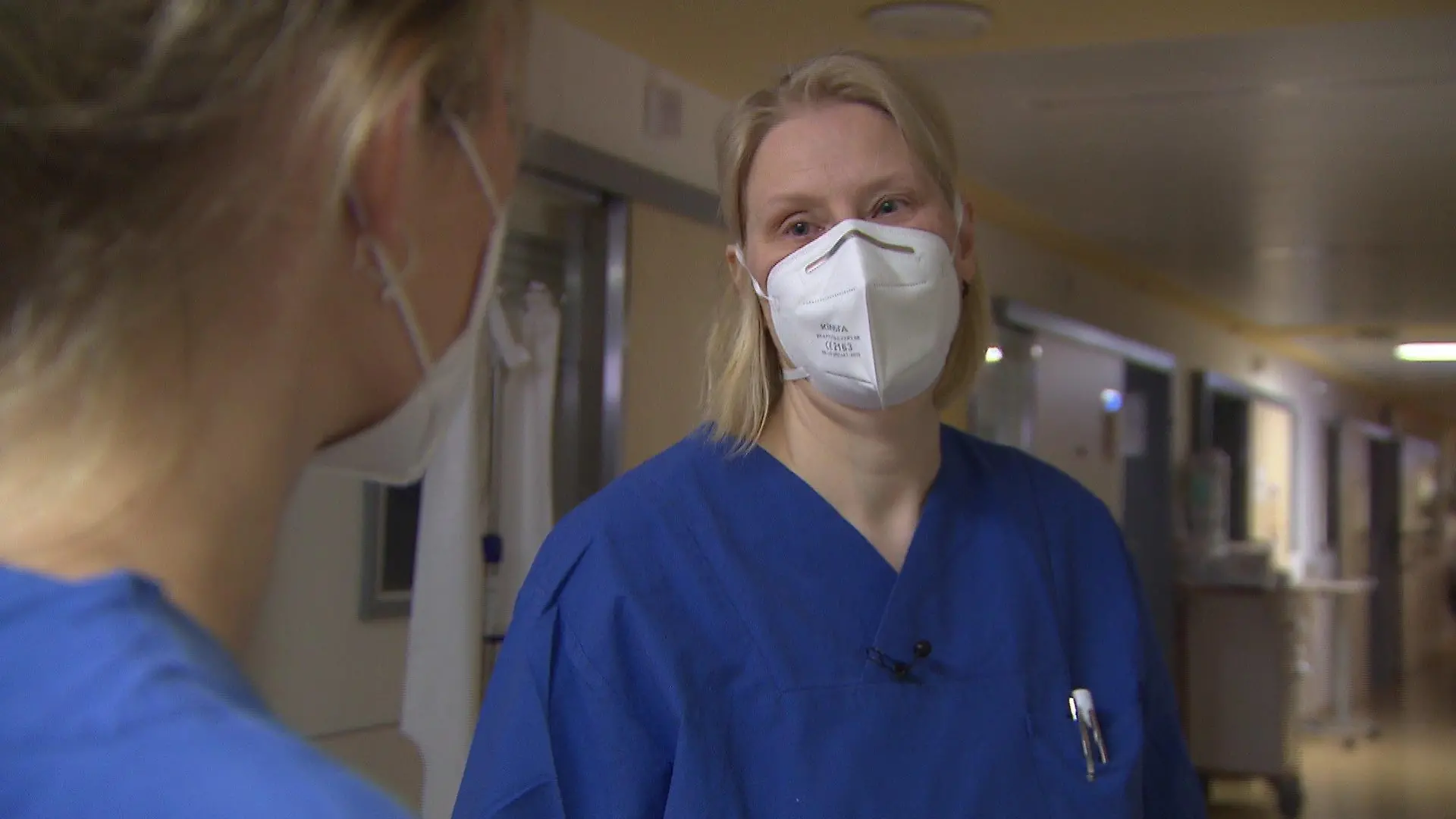 Xenia Franke trägt blaue Arbeitskleidung und ist im Profil abgebildet.