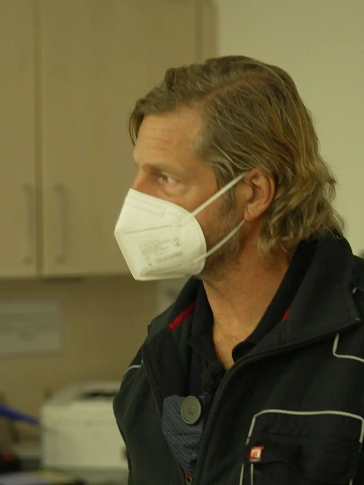Schauspieler Henning Baum ist gelernter Rettungssanitäter. Er steht in Uniform in der Notaufnahme eines Krankenhauses.