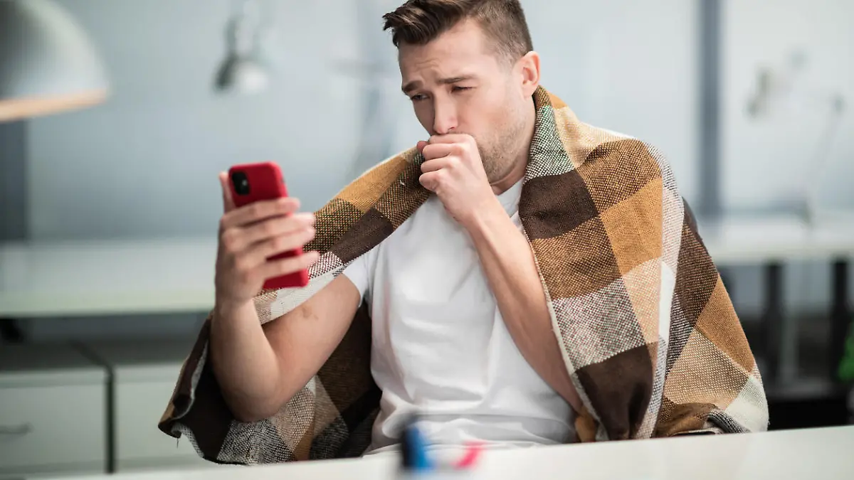 A young office worker is sick with the flu or coronavirus and calls his family on video.