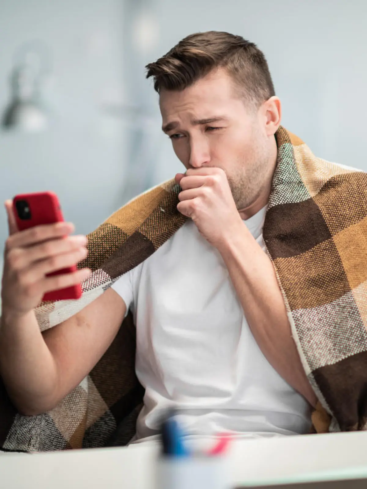 A young office worker is sick with the flu or coronavirus and calls his family on video.