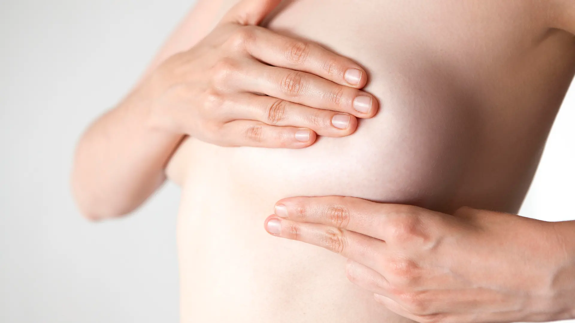 Woman examining her breast with hands