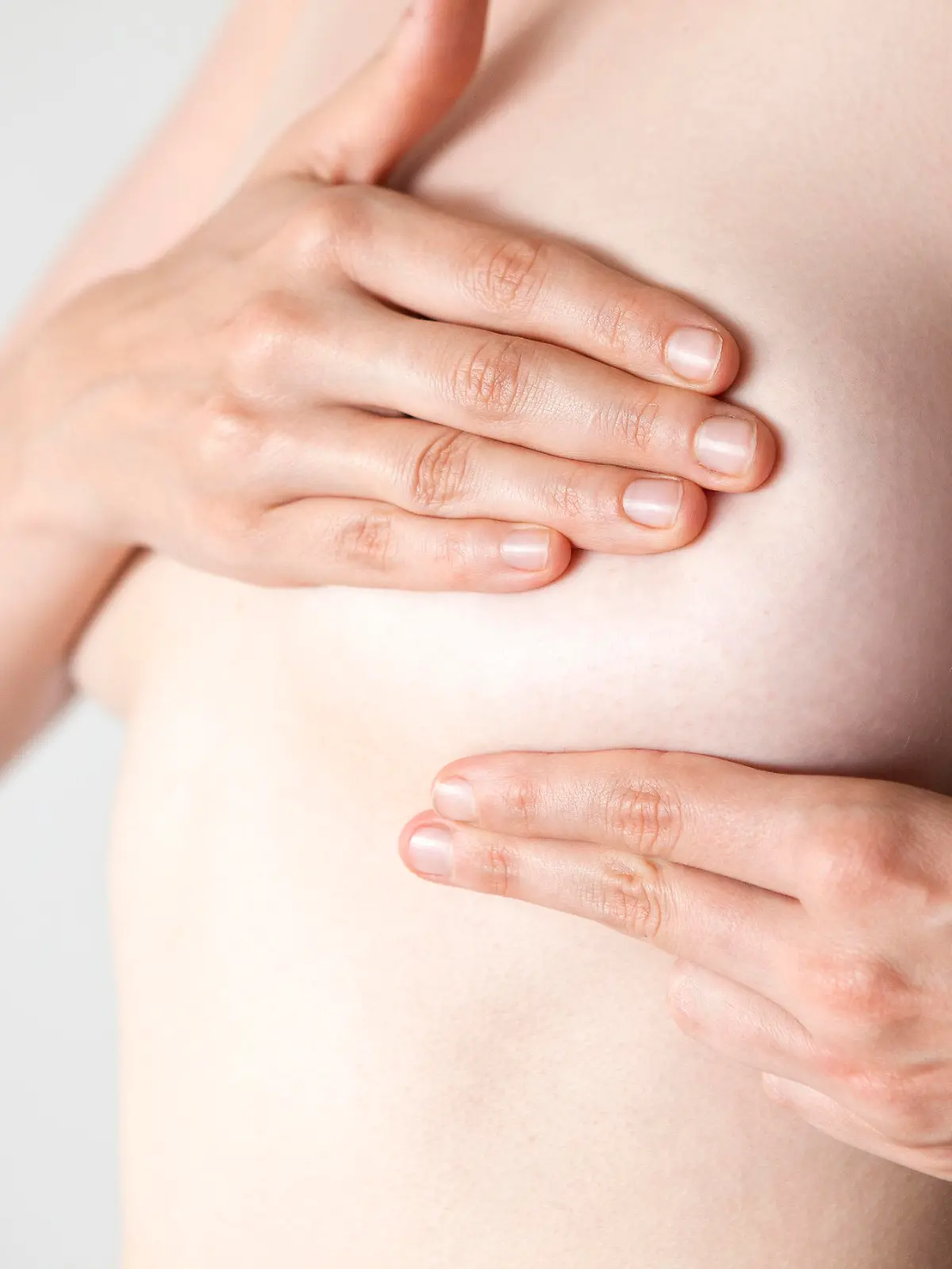 Woman examining her breast with hands
