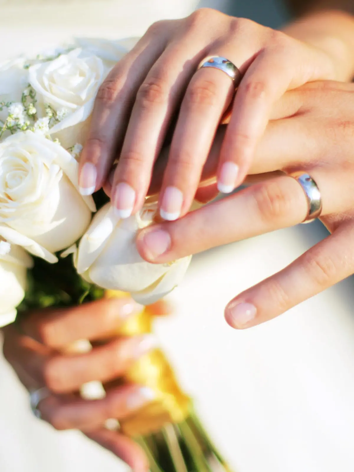 Wedding rings, bouqet and hands holding