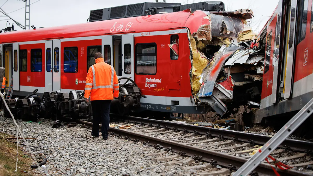 15.02.2022, Bayern, Schäftlarn: Ein Mitarbeiter der Deutschen Bahn geht an der Unfallstelle zweier aufeinander geprallter S-Bahnen in der Nähe des Bahnhofes Ebenhausen-Schäftlarn vorüber. Beim Zusammenstoß zweier S-Bahnen im Landkreis München sind am Montag ein Mensch getötet und mehr als zehn verletzt worden. Foto: Matthias Balk/dpa +++ dpa-Bildfunk +++