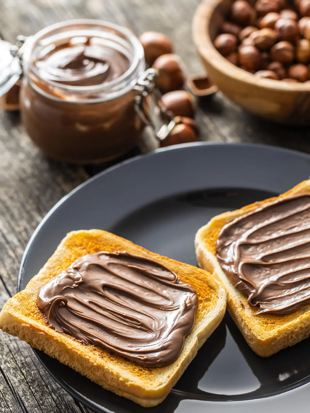 Toast bread with hazelnut spread on plate. Sweet chocolate cream.