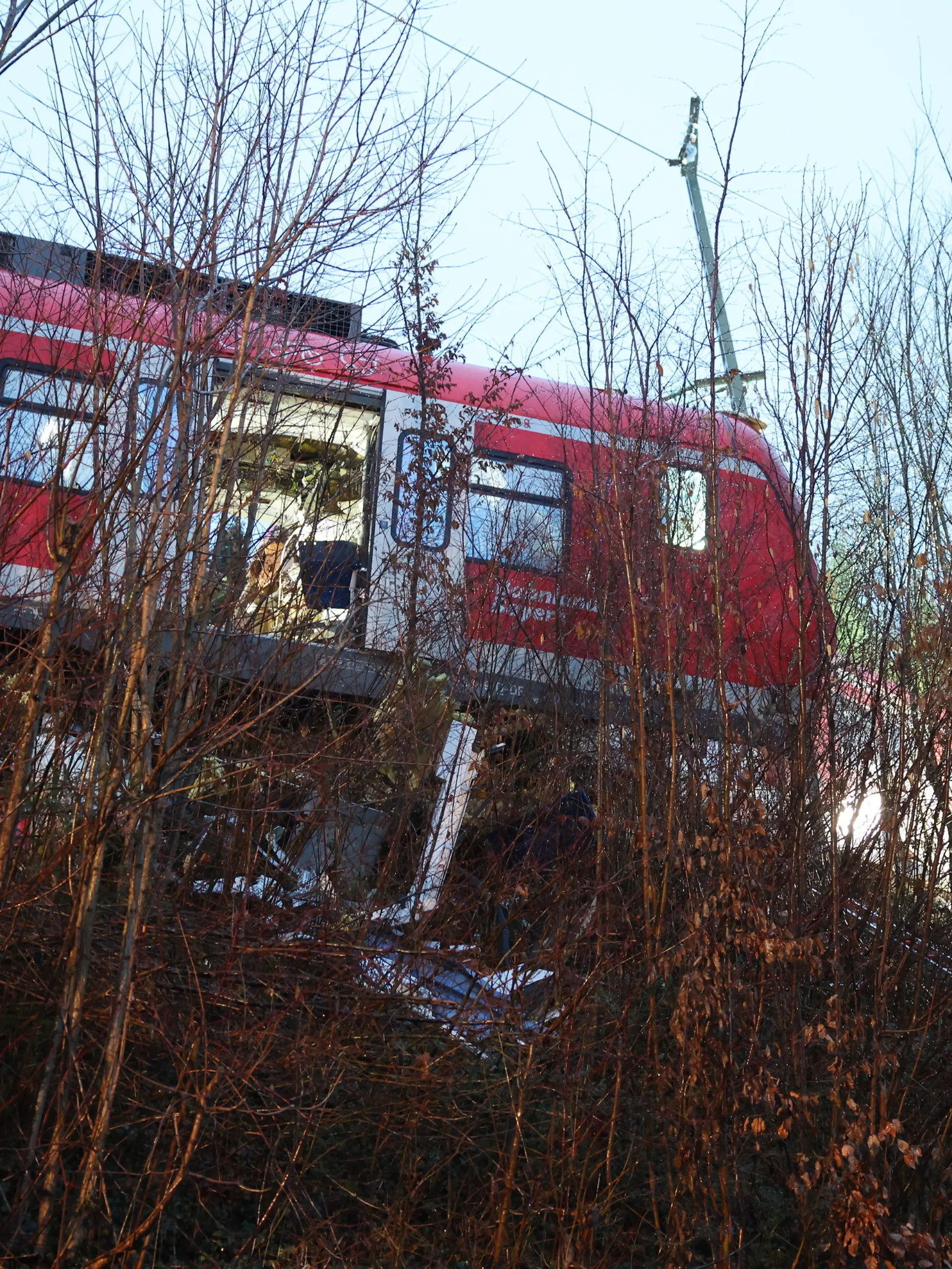 15.02.2022, Bayern, Schäftlarn: Der Triebkopf einer S-Bahn steht an der Unfallstelle auf dem Bahndamm neben dem Gleis. Bei dem Frontalzusammenstoß zweier S-Bahnen im Landkreis München sind am Montag (14.02.2022) ein Mensch getötet und 18 verletzt worden. Foto: Matthias Balk/dpa +++ dpa-Bildfunk +++