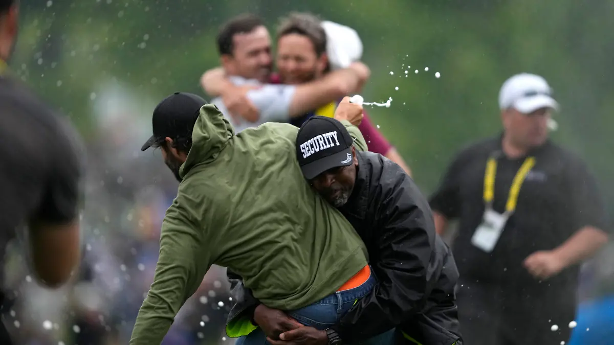 Canadian professional golfer Adam Hadwin, left, is stopped by a security guard while he tries to celebrates with Nick Taylor, of Canada, after Taylor won the Canadian Open golf tournament in Toronto, Sunday, June 11, 2023. (Andrew Lahodynskyj/The Canadian Press via AP)