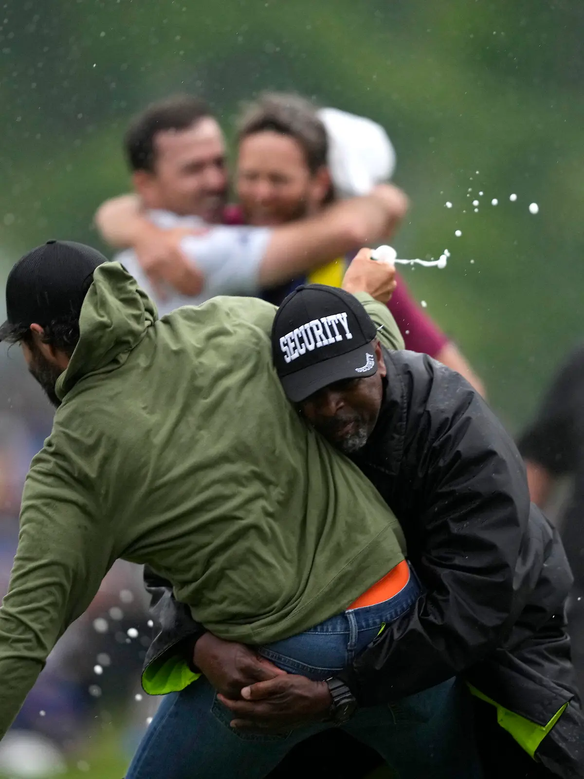 Canadian professional golfer Adam Hadwin, left, is stopped by a security guard while he tries to celebrates with Nick Taylor, of Canada, after Taylor won the Canadian Open golf tournament in Toronto, Sunday, June 11, 2023. (Andrew Lahodynskyj/The Canadian Press via AP)