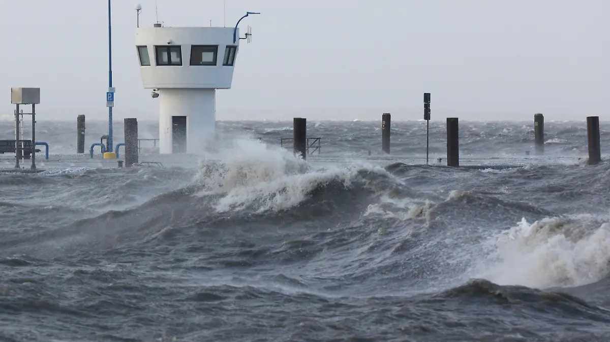 30.01.2022, Schleswig-Holstein, Dagebüll: Wellen der aufgepeitschten Nordsee drücken bei Sturm auf den Fähranleger Dagebüll. Foto: Bodo Marks//dpa +++ dpa-Bildfunk +++