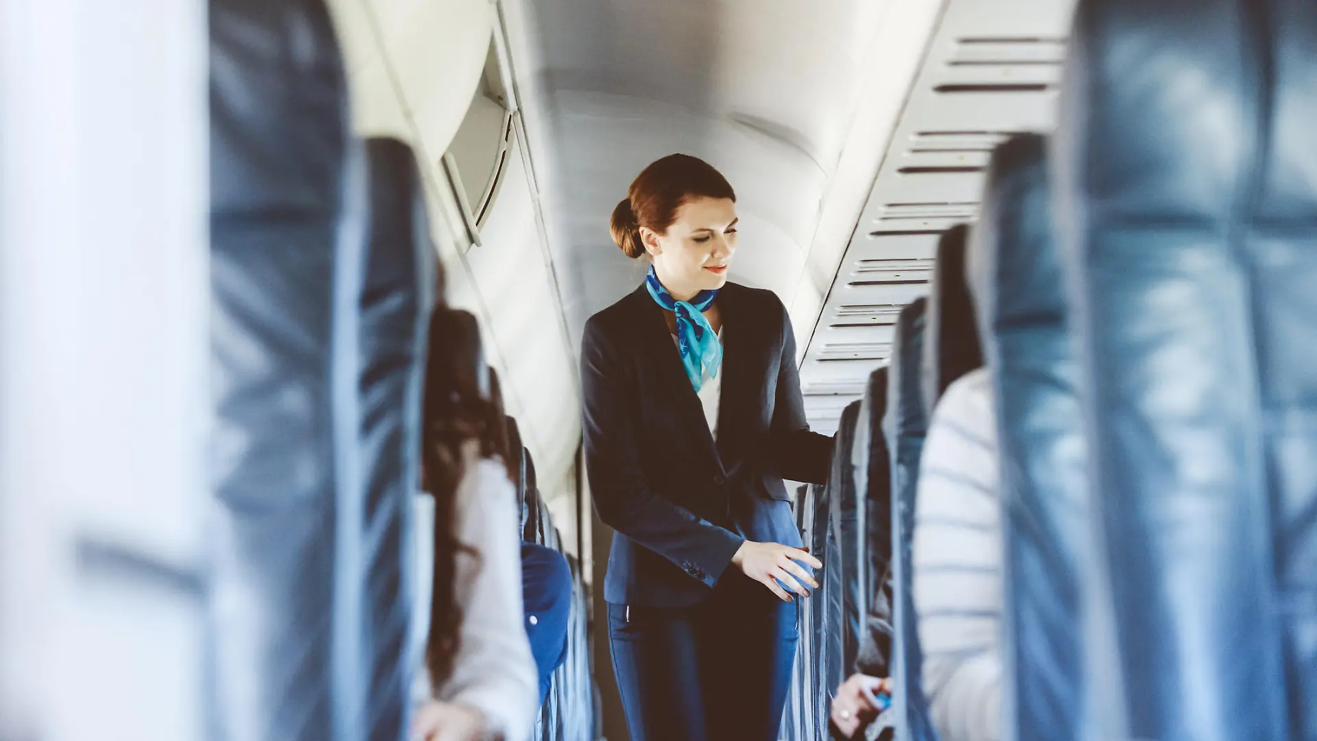 Beautiful air stewardess inside an airplane.