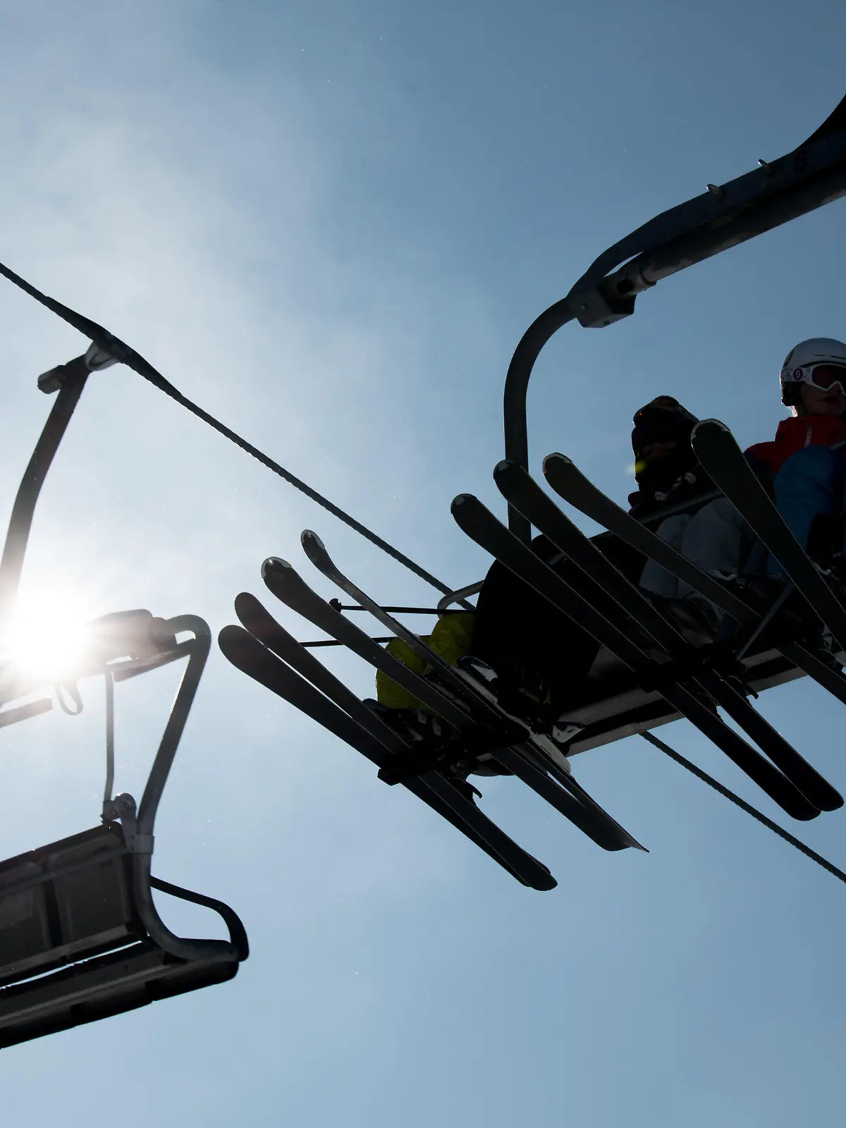 21.02.2018, Sachsen, Schöneck: Skifahrer sitzen bei sonnigem Wetter im Sessellift. Foto: Monika Skolimowska/dpa-Zentralbild/dpa +++ dpa-Bildfunk +++
