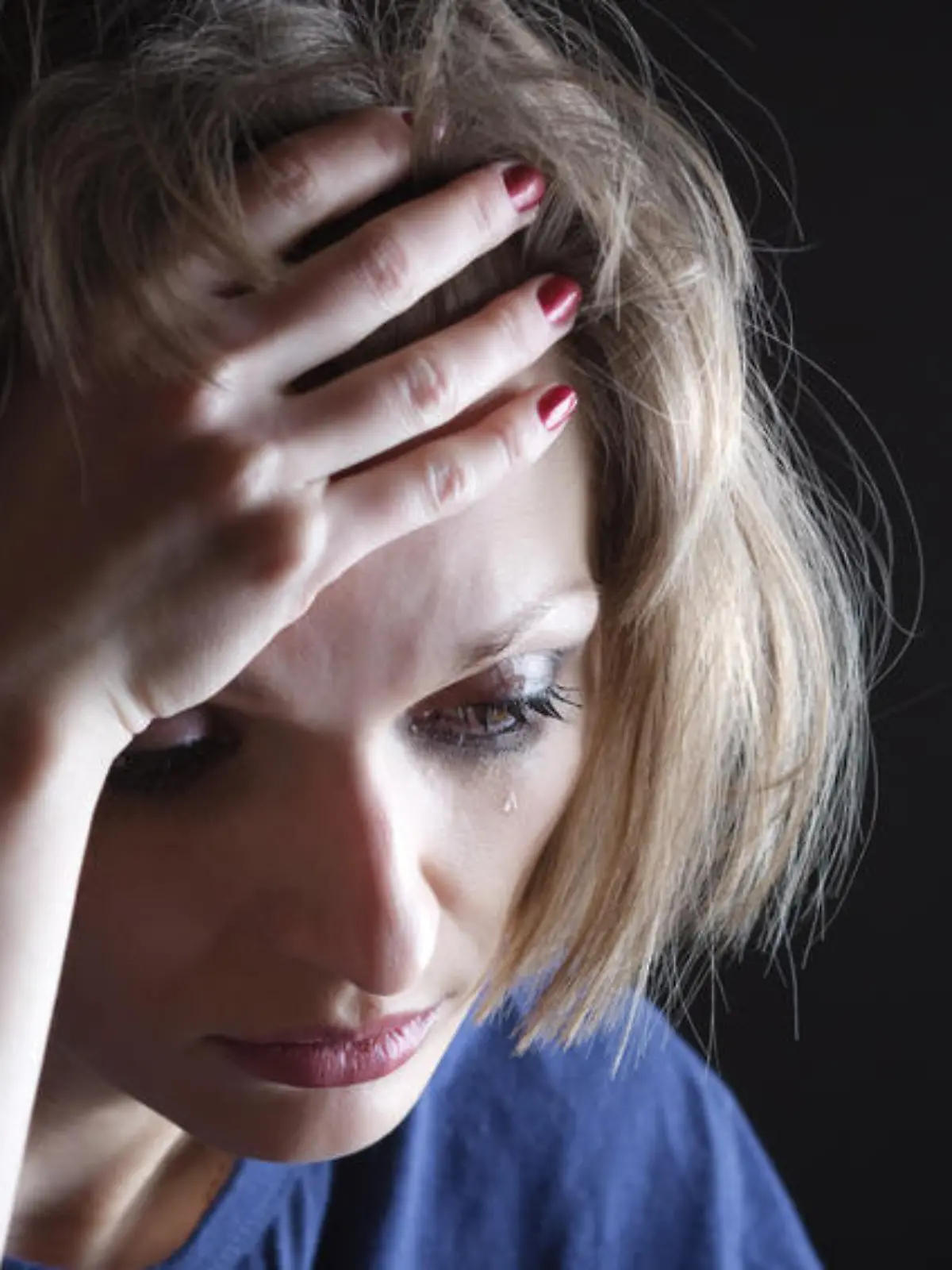 Portrait of sad woman crying, with her hand on the forehead and the tear on her cheek
