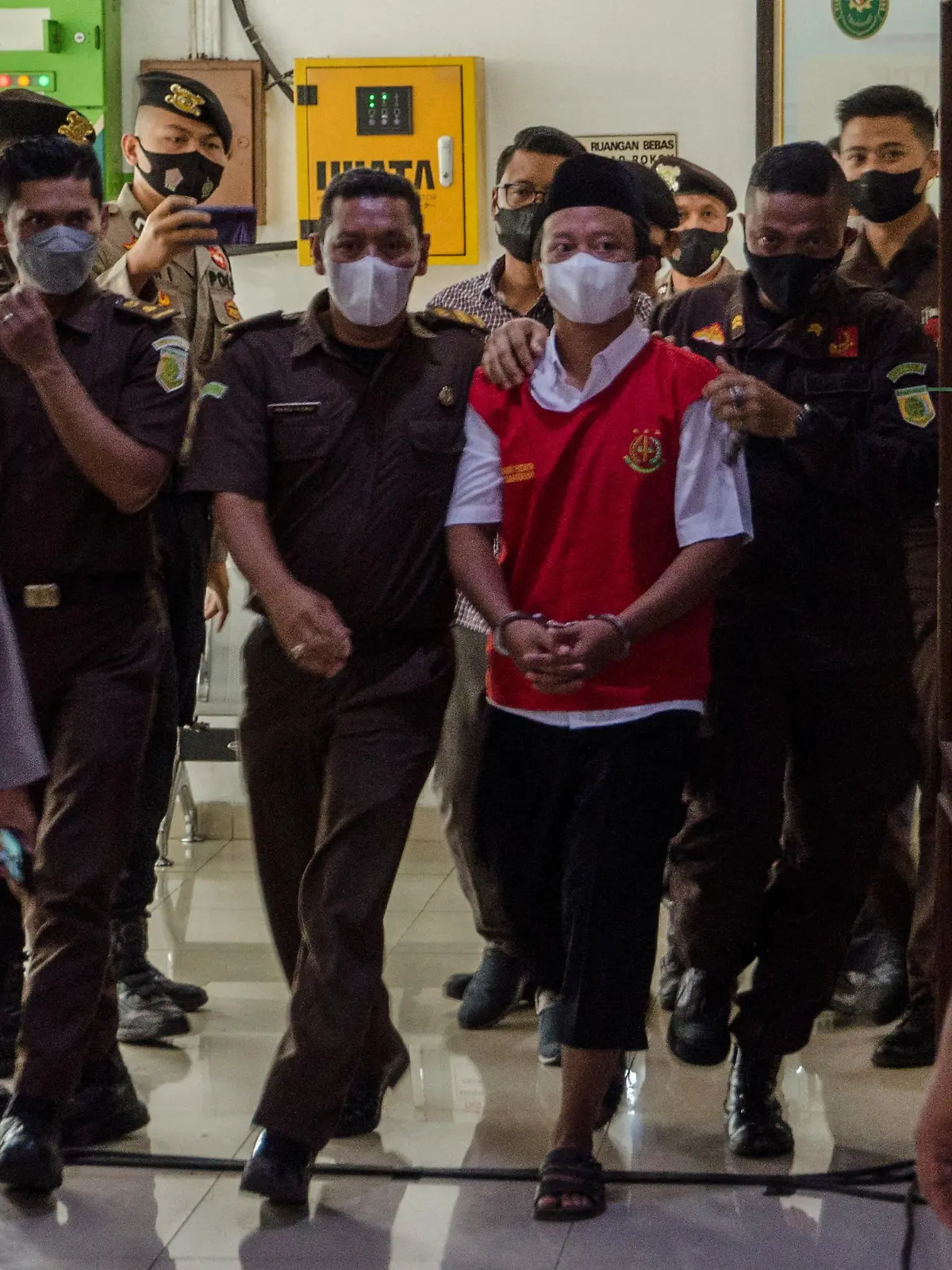 Herry Wirawan (36), a former teacher and founder of an Islamic boarding school, who is accused of raping 13 school girls between 2016 and 2021, is escorted by officers to the court room prior to his verdict trial, at the district court in Bandung, West Java province, Indonesia February 15, 2022 in this photo taken by Antara Foto. Antara Foto/Novrian Arbi/via REUTERS ATTENTION EDITORS - THIS IMAGE HAS BEEN SUPPLIED BY A THIRD PARTY. MANDATORY CREDIT. INDONESIA OUT. NO COMMERCIAL OR EDITORIAL SALES IN INDONESIA.