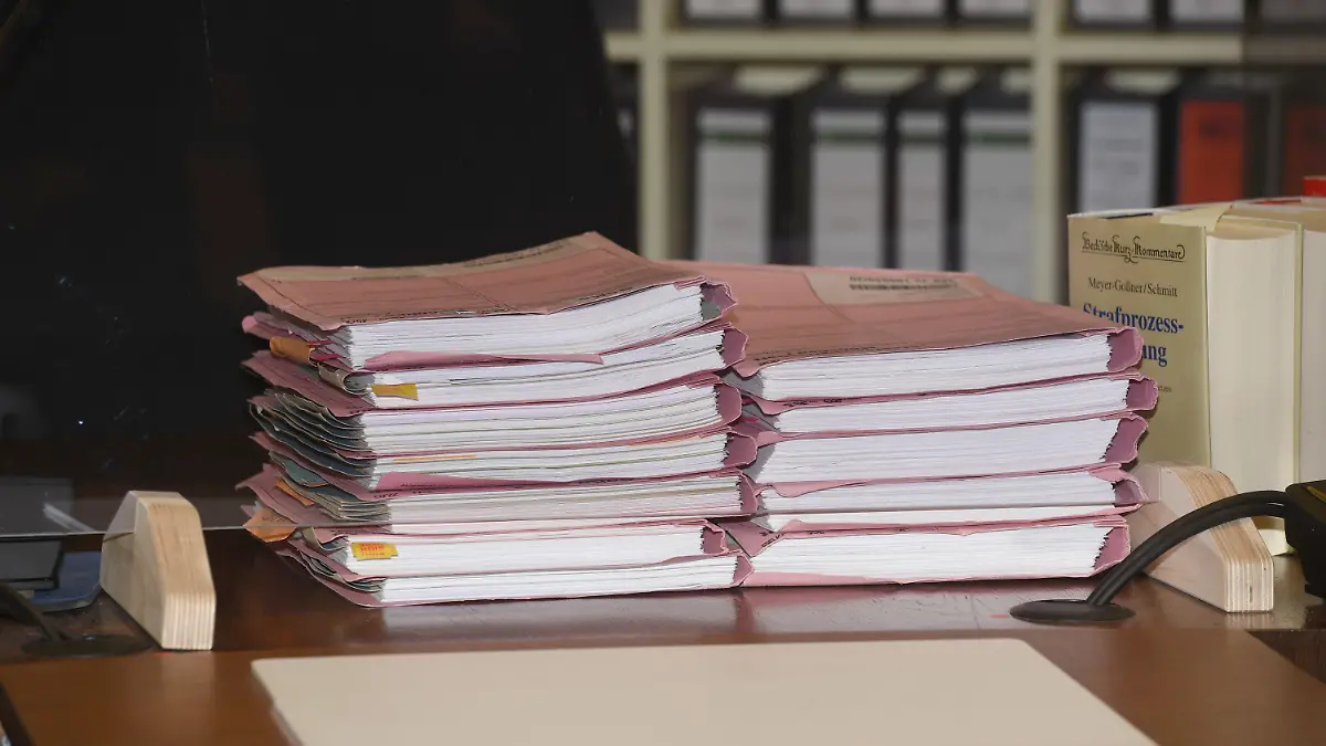 10.02.2022, Bayern, München: Akten liegen im Gerichtssaal beim Auftakt im Prozess gegen einen Polizisten, der in den Drogenskandal im Münchner Polizeipräsidium verwickelt sein soll, im Gerichtssaal des Amtsgericht München auf dem Richtertisch. Nun beginnt ein weiterer Prozess. (zu dpa «Justiz arbeitet Drogen-Skandal bei der Polizei auf») Foto: Felix Hörhager/dpa +++ dpa-Bildfunk +++