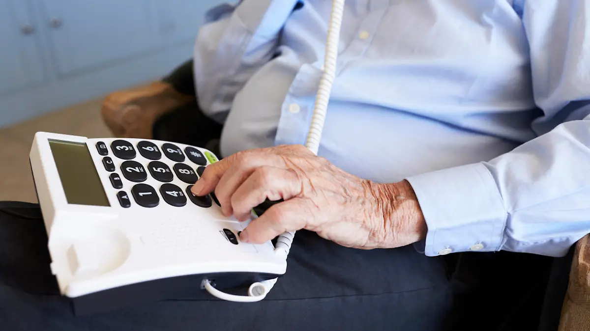 Senior Man At Home Using Telephone With Over Sized Keys