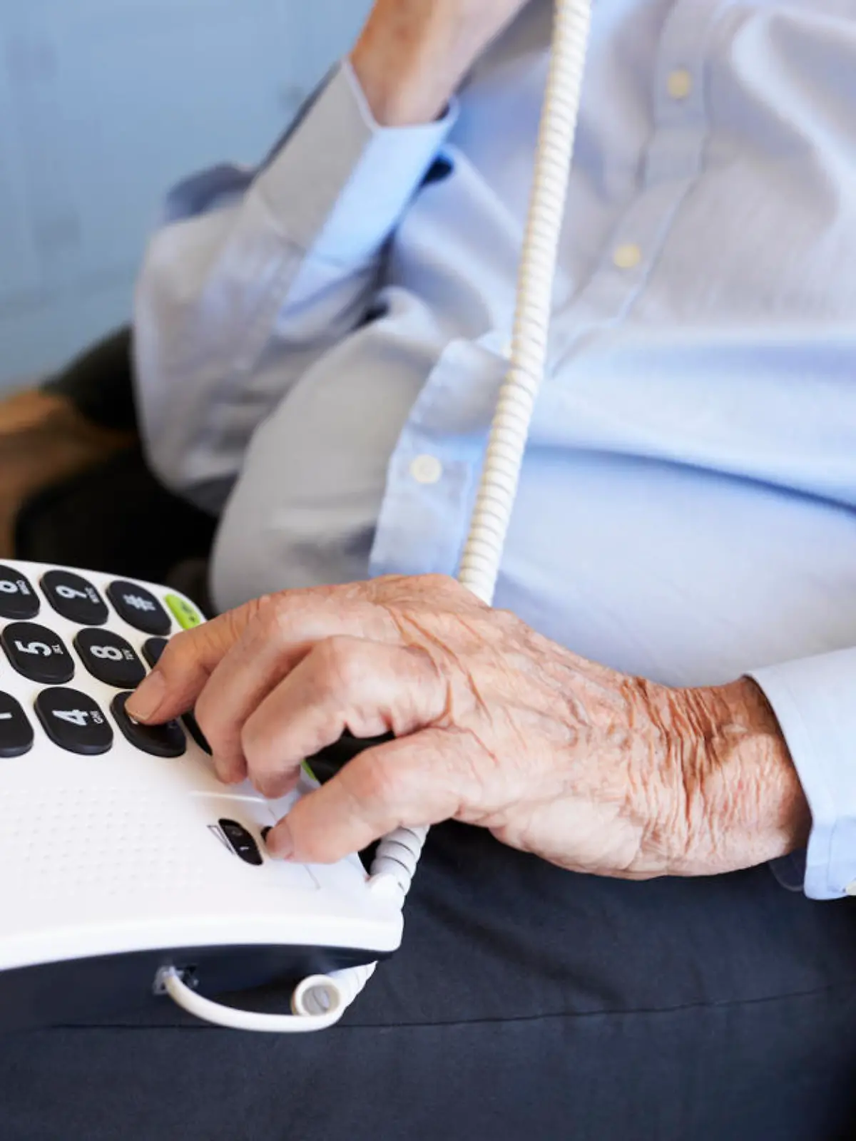 Senior Man At Home Using Telephone With Over Sized Keys