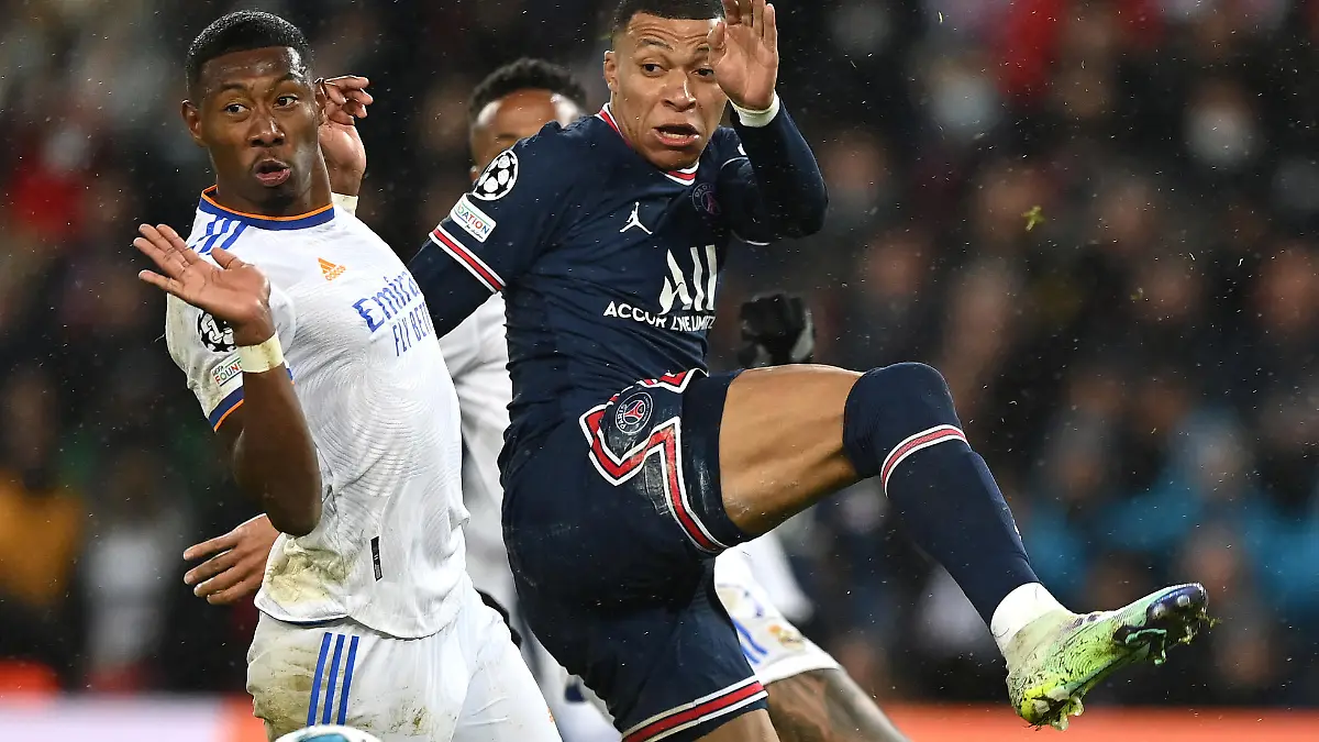 PARIS, FRANCE - FEBRUARY 15: Kylian Mbappe of Paris Saint-Germain challenges David Alaba of Real Madrid during the UEFA Champions League Round Of Sixteen Leg One match between Paris Saint-Germain and Real Madrid at Parc des Princes on February 15, 2022 in Paris, France. (Photo by Shaun Botterill/Getty Images)