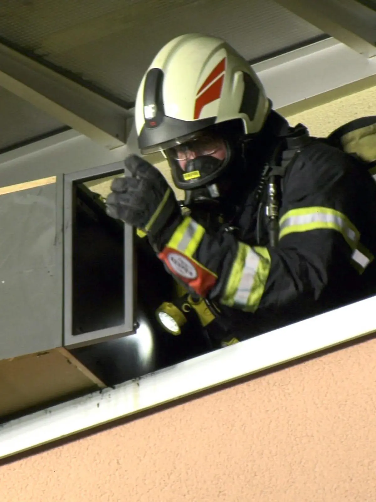 14.02.2022, Hessen, Darmstadt: Ein Feuerwehrmann wirft Mobiliar vom Balkon der brennenden Wohnung. Ein Mann ist bei einem Wohnungsbrand in Darmstadt lebensgefährlich verletzt worden. Nach ersten Erkenntnissen entstand das Feuer am Sonntag an einem Ethanolofen, wie die Polizei mitteilte. Foto: Alexander Keutz/Keutz TV/dpa +++ dpa-Bildfunk +++