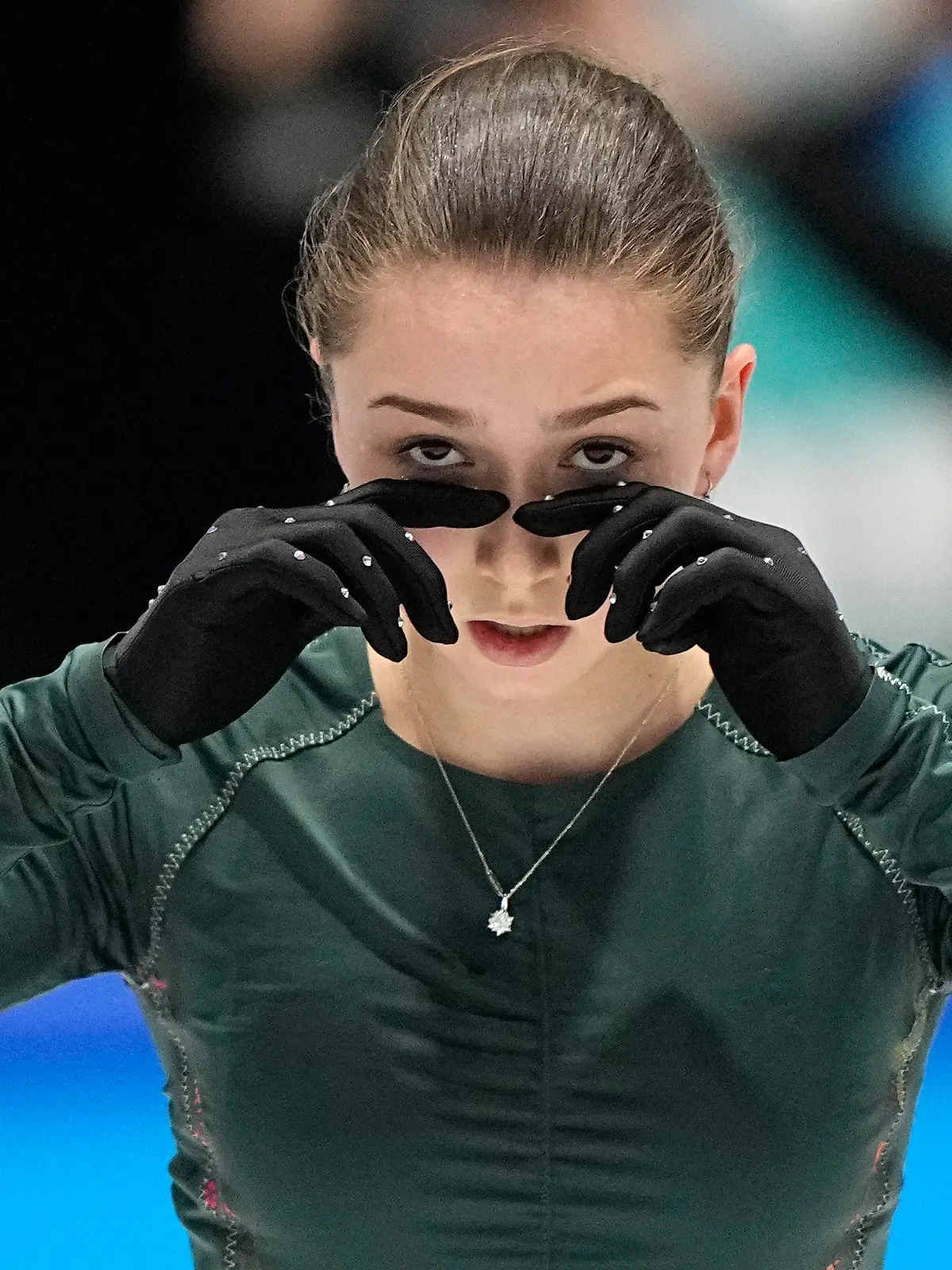 13.02.2022, China, Beijing: Olympia, Eiskunstlauf, Damen, Training, im Hauptstadt-Hallenstadion, Kamila Walijewa vom Russischen Olympischen Komitee trocknen sich die Tränen unter ihren Augen. Walikewa war beim Training gestürzt. Foto: David J. Phillip/AP/dpa +++ dpa-Bildfunk +++