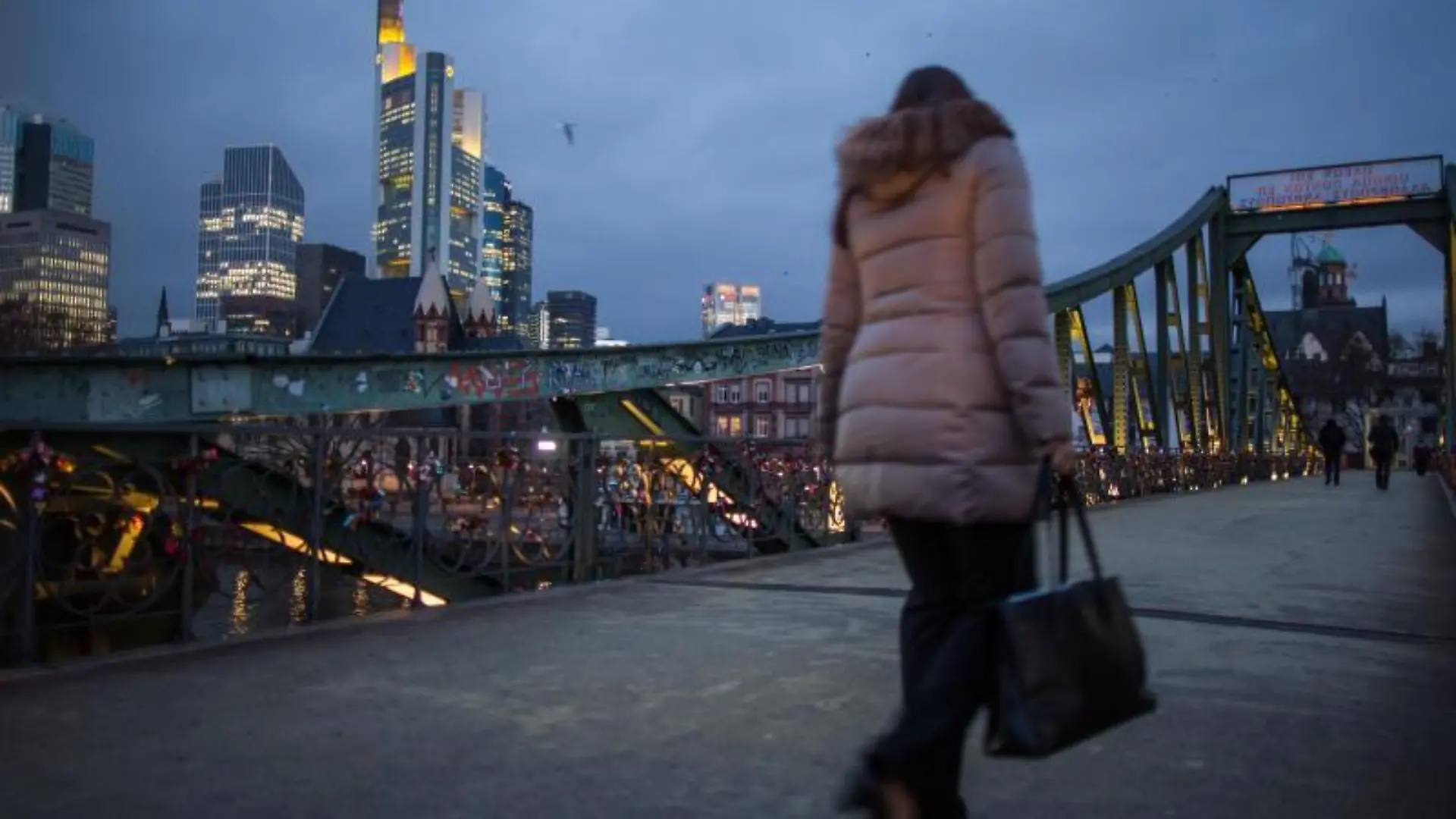 Frau geht über Eiserner Steg in Frankfurt/Main