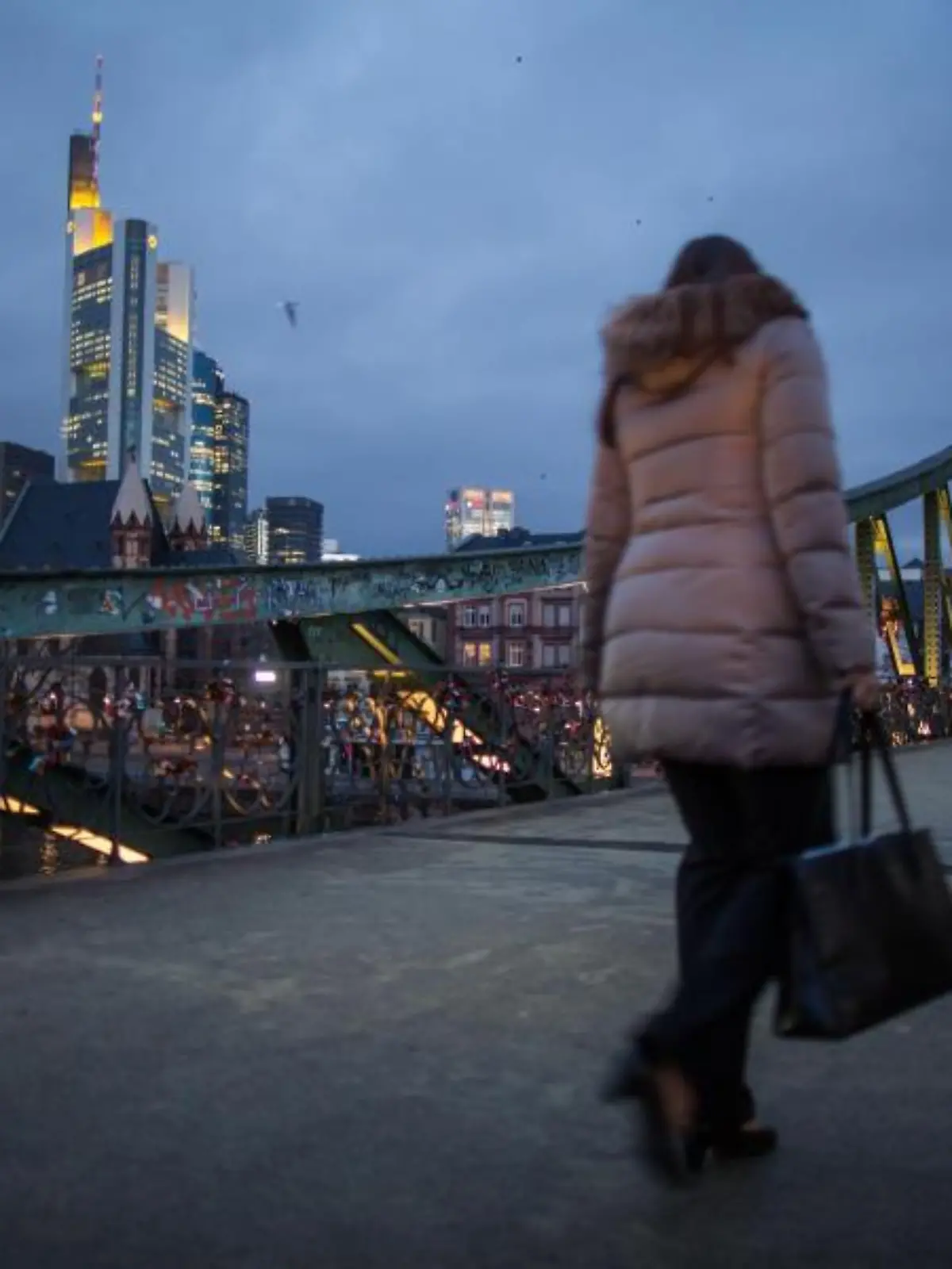 Frau geht über Eiserner Steg in Frankfurt/Main