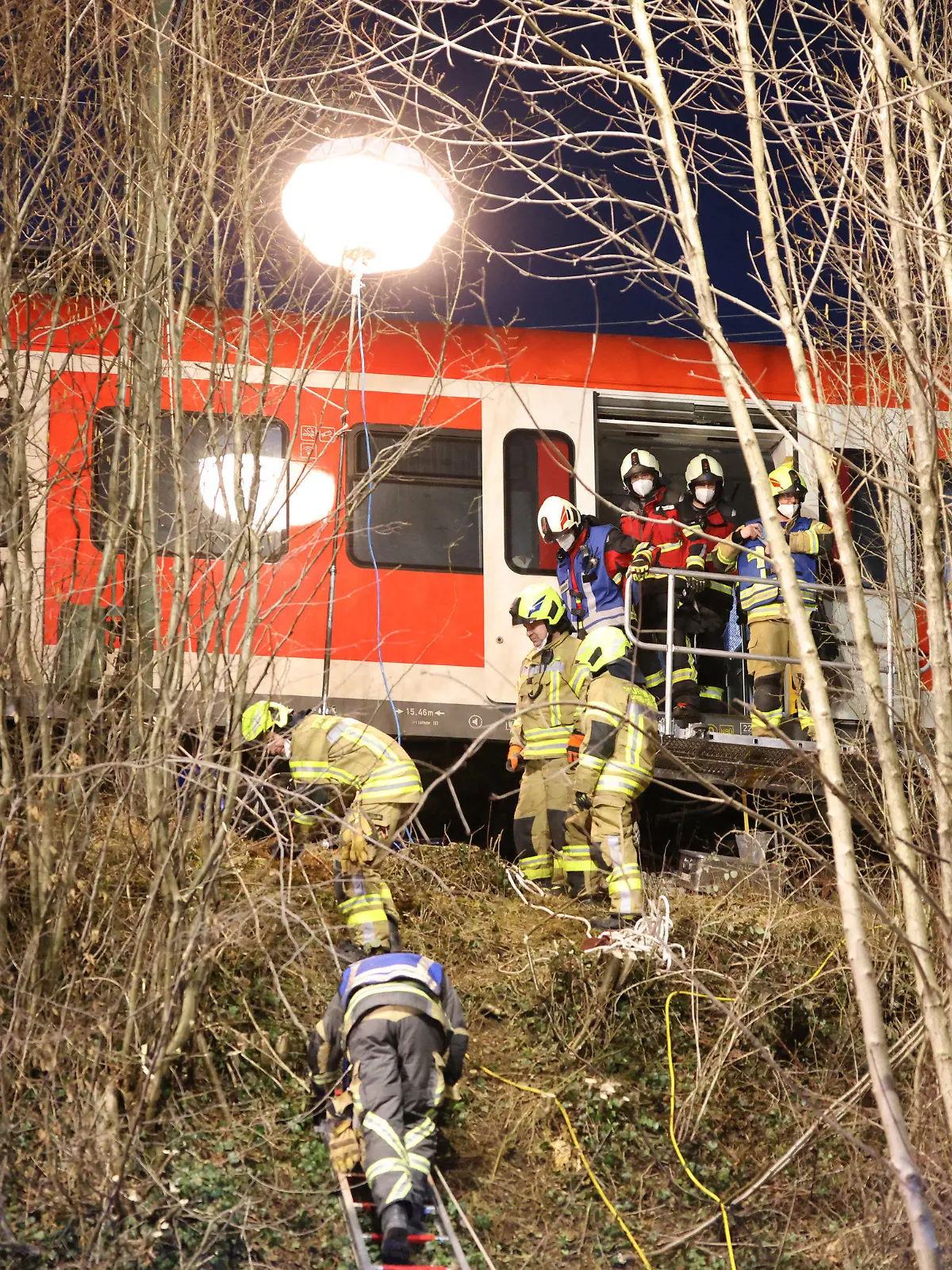 dpatopbilder - 14.02.2022, Bayern, Schäftlarn: Rettungskräfte arbeiten an der Unfallstelle. Beim Zusammenstoß zweier S-Bahnen im Landkreis München sind am Montag ein Mensch getötet und mehr als zehn verletzt worden. Es habe eine niedrige zweistellige Zahl an Verletzten gegeben, berichtete ein Sprecher des Münchner Polizeipräsidiums. Foto: Matthias Balk/dpa +++ dpa-Bildfunk +++